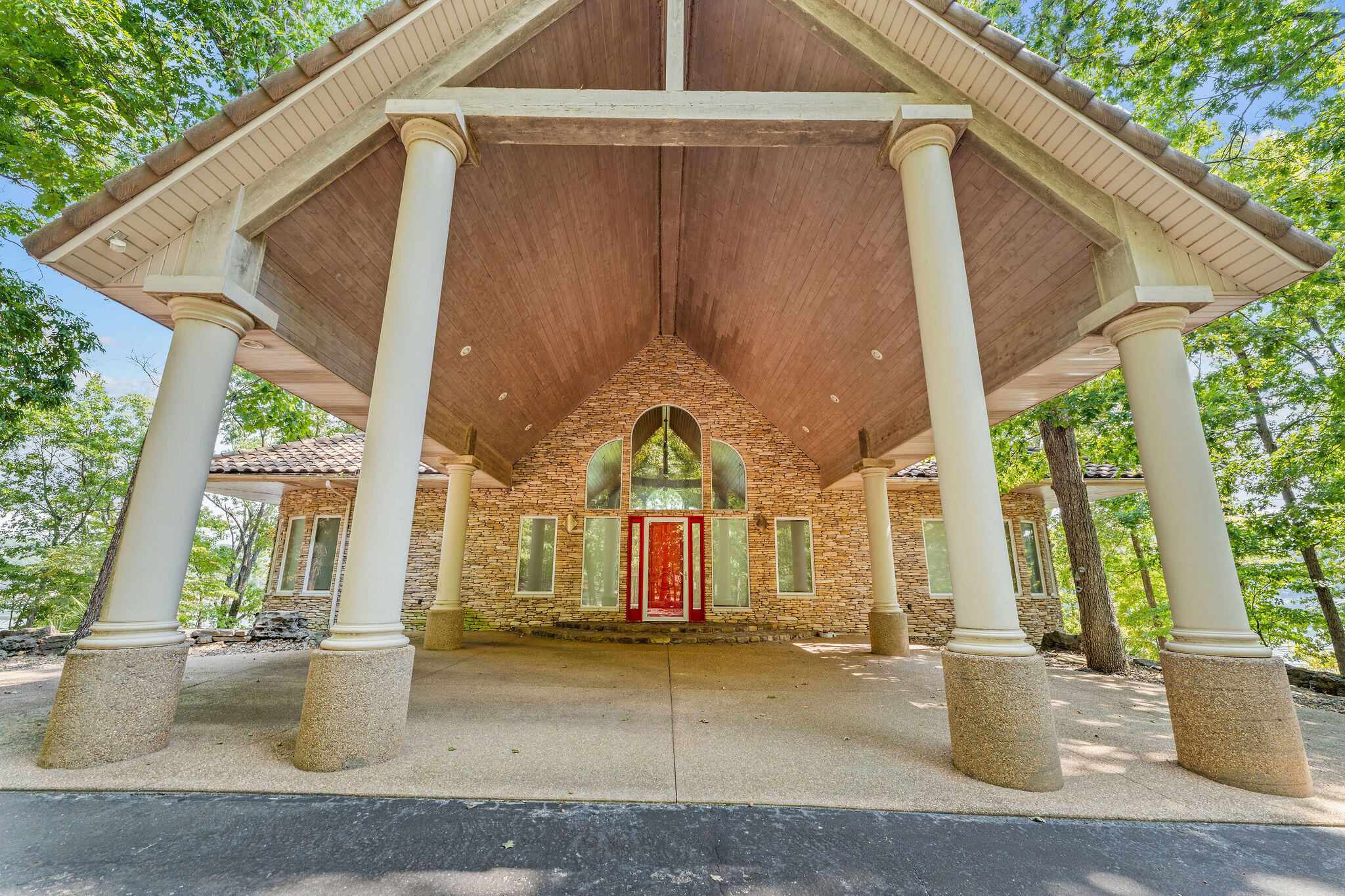 Perched on a private point along the shores of Table Rock Lake, this completely furnished 5428 sqft modern-designed home is all about sleek lines, open spaces, and jaw-dropping water views. Expansive walls of glass frame the lake from nearly every room creating a seamless blend of indoor and outdoor living. The open-concept design features soaring ceilings, clean architectural details, and a natural palette of stone and wood that mirrors the beauty of its surroundings.The kitchen flows effortlessly into spacious living and dining areas with a large capacity free standing ice maker.  All baking up against the backdrop of endless lake vistas. Step outside to the deck where the horizon stretches across miles of sparkling water. A short drive down the road leads to a boat slip on a community dock with a boat lift and a  hanging boat cover installed to wrap and protect your boat.  Need room for guests to visit during the summertime? No worries, above the detached garage with 3 parking spaces, 1/2 bath and a shop area is a 1900sqft fully functioning fully furnished 4 bedroom  and 4 bathroom guest house.  This guest house is fun for the kids with a firepole extending from the loft to the main living area.This is more than a home--it's a statement of modern lakeside living, designed for those who value luxury, privacy, and panoramic beauty.