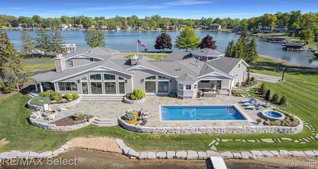 This one-of-a-kind waterfront home boasts an extraordinary 830 ft of frontage on all sports Lake Fenton. Privately positioned on a rare peninsula with nearly 2 acres of land, this exceptional property is surrounded by water & offers unmatched views & seclusion. This entertainer’s dream, completely rebuilt & expanded from the foundation up in 2017 with custom finishes throughout. The great room is nothing short of breathtaking, with soaring ceilings, exposed wood beams, a striking natural stone fireplace, & expansive lake views. The open concept kitchen is thoughtfully designed with built-in appliances, quartz countertops, marble backsplash, & a walk-in pantry. The spacious primary suite is a true retreat, offering serene pool & lake views, a cozy fireplace, & direct access to the built-in hot tub just steps away. The spa-like primary bath features heated floors & a standalone soaking tub for ultimate relaxation. Three upper-level bedrooms each enjoy picturesque water views, while a spacious bonus room above the garage provides versatile space ideal for a private home gym, media room, or casual hangout. Outdoor living rivals that of a luxury resort. Two covered seating areas & an expansive custom bluestone patio surround the in-ground saltwater pool & built-in fire pit, offering multiple spaces to entertain, unwind, & take in the setting. Just beyond, approximately 100 feet of sandy shoreline invites effortless access to the lake. A 1,500 SF, 3+ car garage accommodates even the largest vehicles with ease & includes a conveniently located half bath just steps from the pool. The professionally landscaped grounds allow for future expansion, including ample space to build an additional garage or guest quarters, while still leaving space for outdoor sports. This exceptional property offers a lifestyle defined by rarity, elegance, and absolute waterfront prestige! ALL BUYERS must have pre-approval letter or proof of funds to schedule a showing NO EXCEPTIONS!