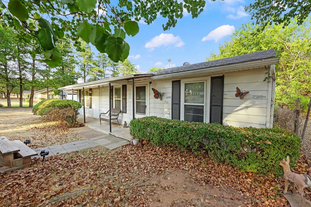 CHARMING BUNGALOW ON ¾ ACRE WITH A LITTLE SOMETHING EXTRA! This inviting two-bedroom, one-bath bungalow offers fresh appeal with new flooring and new interior paint throughout, along with ceiling fans and a comfortable, functional floor plan. The living room flows into the kitchen and adjoining dining area, creating an easy space for everyday living and casual meals. The kitchen offers plenty of cabinet storage and a gas range, while the convenient interior laundry room adds to the home's functionality. With the right offer, the refrigerator, microwave, washer and dryer can remain.  Situated on approximately three-quarters of an acre, there is room to enjoy the outdoors, watch for local wildlife, garden, play or simply relax. A carport provides covered parking, and a well house is located just behind it. And wait until you see the little bonus building out back! Water is available to the building, and electrical service is in place but will need to be connected. With a little finishing work, it could become whatever you've been wishing for—a she-shed, reading retreat, craft room, playhouse, hobby space or simply your own little place to disappear for a while. Bring your imagination and make this charming extra space your own! If you're looking for a home with fresh updates, usable land and a little extra space to make your own, this charming bungalow is worth a look.  WELCOME HOME!