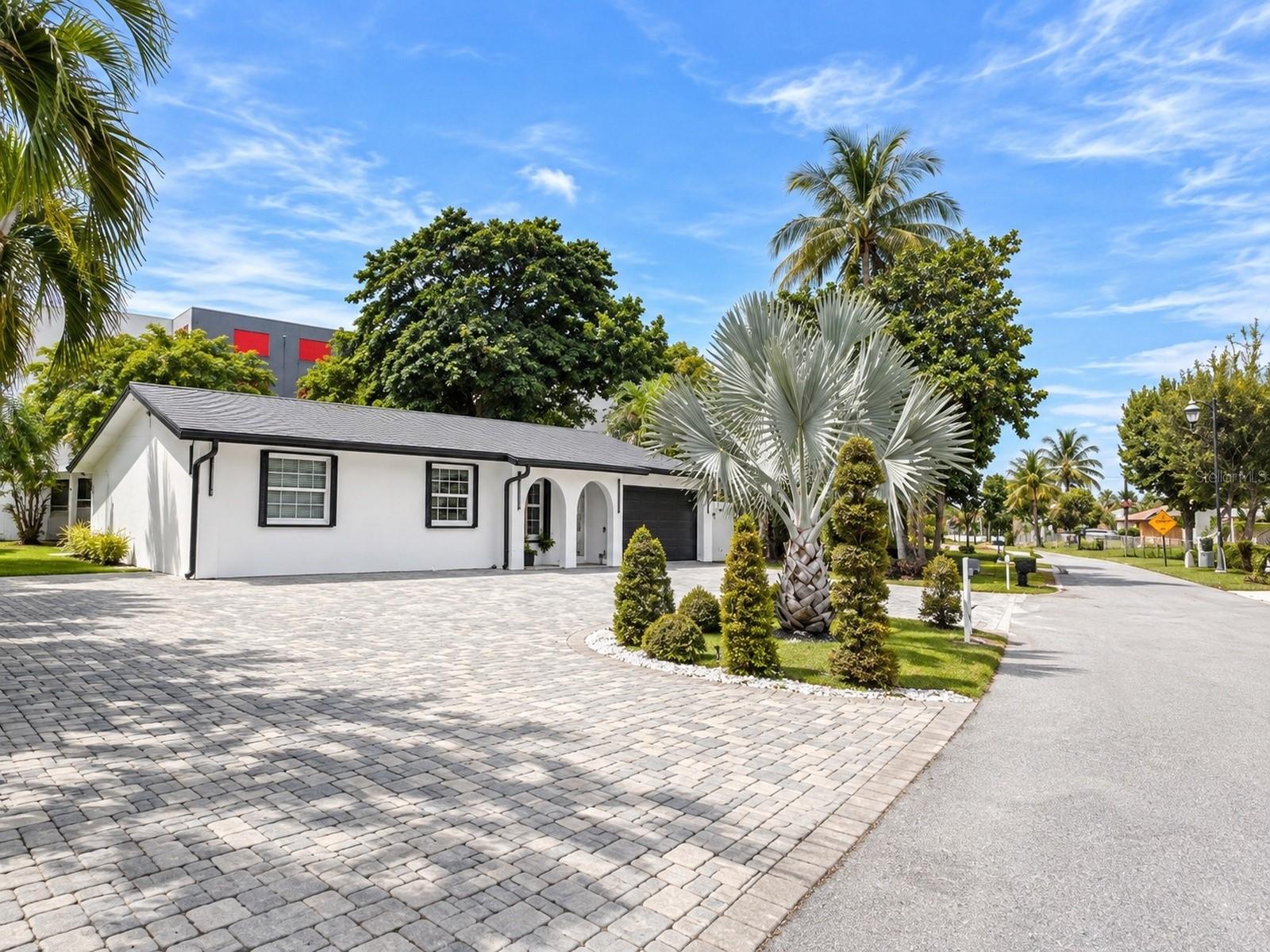 Enjoy a convenient Mangonia Park location approximately 10 minutes by car from the beach, with easy access to I-95, the Mangonia Park Tri-Rail station and nearby medical facilities, including St. Mary’s Medical Center. From the restaurants, boutiques and galleries of Northwood Village to shopping and dining at CityPlace and evenings along downtown West Palm Beach’s waterfront, this address keeps everyday essentials and favorite destinations within reach.Arrive home to a sweeping semicircular paver driveway framed by lush tropical landscaping and beautifully sculpted topiaries. Fresh exterior paint, crisp modern accents and a welcoming covered entry create a memorable first impression at this extensively renovated, move-in-ready three-bedroom, two-bath residence.Inside, bright, open living spaces invite you to gather, entertain and settle into the comfort of home. Crown molding throughout, expansive marble-look porcelain tile, fresh paint, modern lighting and new window treatments create a polished, cohesive setting. Whether sharing a quiet evening or welcoming guests, these thoughtfully updated interiors provide a beautiful backdrop for everyday life.The new, expanded kitchen is a natural gathering place, pairing modern cabinetry with quartz countertops with water fall, a coordinating backsplash and modern appliances. Prepare a weekday breakfast, try a new recipe or bring everyone together for a special occasion in a space that balances contemporary style with everyday function. The range, microwave, refrigerator and dishwasher are included. Both fully renovated bathrooms continue the refined aesthetic with frameless glass showers, striking marble-look finishes, vessel sinks and decorative lighting.The insulated converted garage adds a versatile, air-conditioned music and family room with its own dedicated mini-split system. Enjoy movie nights, games, favorite songs or creative pursuits in a comfortable space that expands your options without sacrificing a bedroom. Currently arranged for music and gathering, this bonus area can adapt to your interests and also offers potential for conversion back to garage use.Step outside to an approximately quarter-acre fenced lot with room to play, garden, entertain and unwind. The generous backyard welcomes outdoor games and weekend gatherings, while an above-ground pool offers a refreshing way to enjoy sunny days at home. Mango and papaya trees bring tropical character to the landscape, with ample lawn space to make your own. An irrigation system supports the landscaped grounds, and an outdoor storage shed keeps tools, gardening supplies and seasonal items conveniently tucked away.Practical features complement the home’s beautiful finishes, including a metal roof, upgraded windows, hurricane shutters and gutters. Window security sensors and a Ring doorbell add everyday convenience. The property also features a leased solar system, with transfer to the new owner subject to approval.From its distinctive landscaped arrival to its renovated kitchen, flexible gathering spaces and spacious backyard, this home brings together comfort, character and connection. Move in, make it your own and enjoy room for the moments that matter. Schedule your private showing today to experience the details that make this property feel like home.