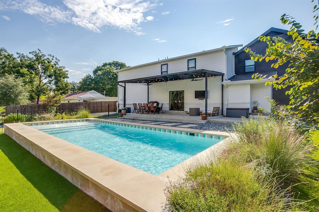 Step into timeless mid-century design where style meets function! Clean lines, open spaces, and thoughtfully designed interiors. The backyard feels like a private oasis with a sparkling pool, low maintenance turf lawn, and a spacious covered patio perfect for year round outdoor living. Inside, the open floorplan offers generous living and storage throughout. The first level includes an inviting living room with vaulted ceiling, an open kitchen with walk-in pantry, and a convenient half bath for guests. The primary suite features expansive windows and attached bath with dual sinks, soaking tub, separate shower, and walk-in closet. Upstairs, you’ll find three additional bedrooms, a full bath, a second living area, and a versatile bonus space currently used as an office. Notable improvements include: engineered wood floors throughout (2021), energy-efficient windows (2021), privacy fence (2020), gutters (2025), and turf lawn around the pool and patio. Situated on a tree lined block in Ridglea Hills! Come see it today!