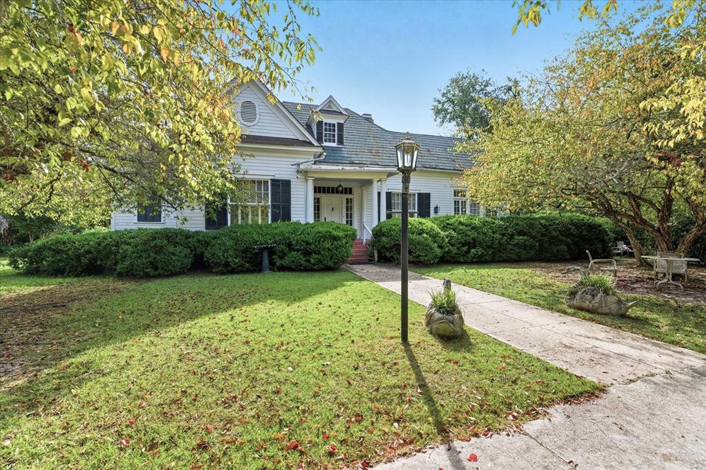 Located on the world-class North Court Street, lined with majestic live oaks draped in Spanish moss, this historic home captures the very best of Southern charm. The original house was much smaller until famed architect Lloyd Greer designed a remarkable expansion, transforming it into the grand residence it is today. In the same family since 1971, it has been lovingly cared for and is now ready for its next chapter.  Inside, hardwood floors lie beneath the carpet, soaring ceilings and multiple fireplaces add warmth and character, and spacious rooms showcase timeless elegance. A formal dining room is perfect for hosting gatherings, while a convenient breakfast room adds everyday functionality. A large sunroom and open porch provide inviting spaces for relaxing and entertaining.  Set on a generous lot in the heart of Quitman, the property also includes its own private tennis court and plenty of outdoor space for gardening, recreation, or gatherings. With its architectural pedigree, historic character, and iconic location, 621 North Court Street is truly one of Quitman's signature homes.
