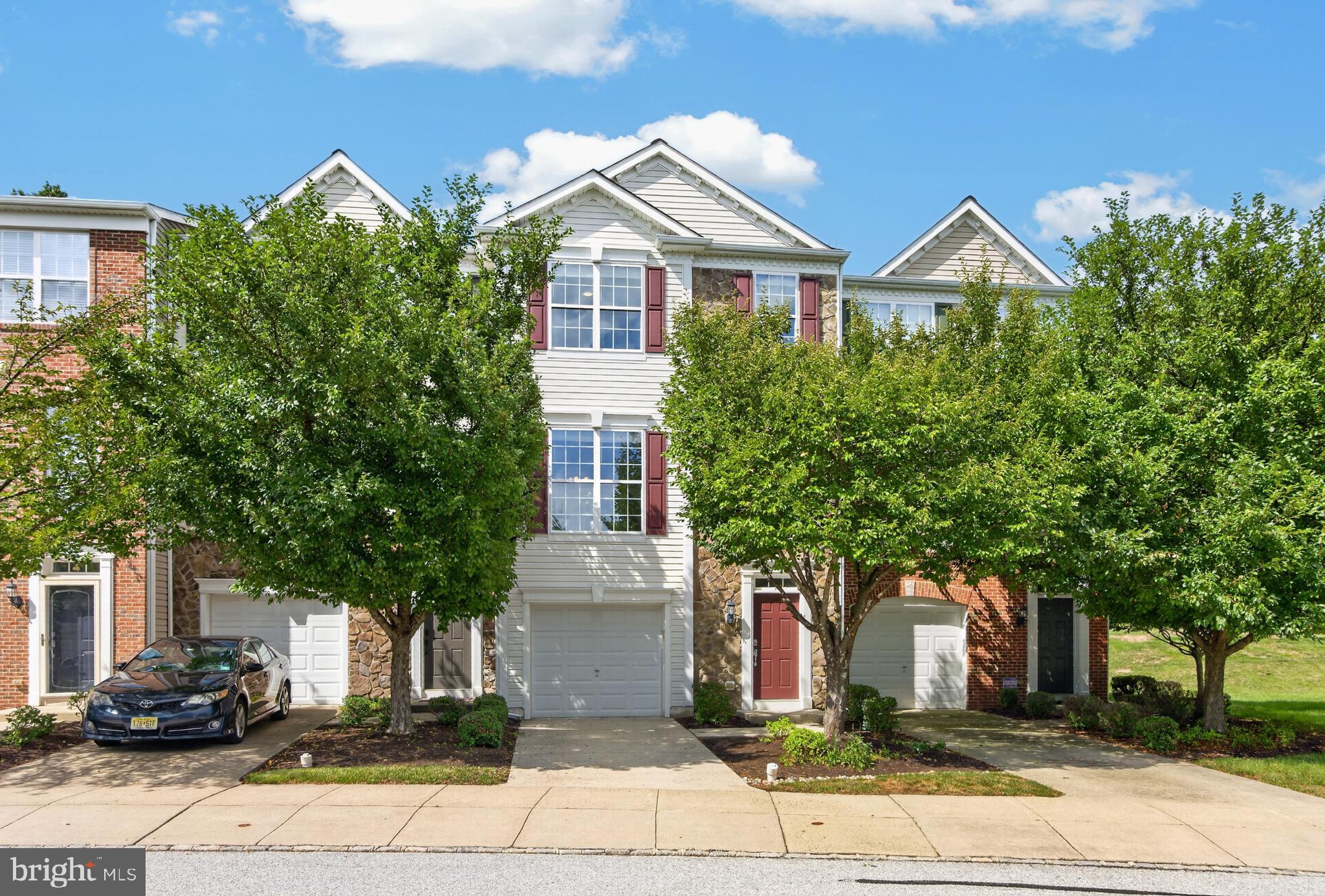 Welcome home to this exceptional four-bedroom, three-and-a-half-bath townhome in the highly sought-after Longford Crossing community, perfectly positioned on one of the neighborhood's premier hilltop lots overlooking a tranquil wooded, park-like setting. Mature trees frame the front of the home, while additional guest parking across the street adds everyday convenience. A standout feature of the home is the brand-new hardwood flooring that extends throughout all three levels and both staircases, creating a seamless, elegant look from top to bottom. The versatile walk-out lower level features a spacious family room, fourth bedroom or home office, full bath, laundry room, utility room, and access to a beautiful paver patio surrounded by nature. The open-concept main level is designed for comfortable living and effortless entertaining, offering expansive living and dining areas enhanced by crown molding, architectural columns, and abundant natural light. The well-appointed kitchen boasts generous cabinetry and counter space, Corian countertops, tile backsplash, recessed lighting, a pantry, breakfast area, and a brand-new stainless steel appliance package including a five-burner gas range, microwave, dishwasher, and refrigerator. Just off the kitchen, the expanded composite deck provides the perfect private retreat to relax and enjoy the peaceful wooded views. Upstairs, the spacious owner's suite offers a walk-in closet and a luxurious en-suite bath featuring dual vanities, a soaking tub, separate shower, and private water closet. Two additional bright bedrooms and a full hall bath complete the upper level. Combining an outstanding location, thoughtful updates, generous living spaces, and exceptional outdoor areas, this move-in-ready home is a rare opportunity you won't want to miss.