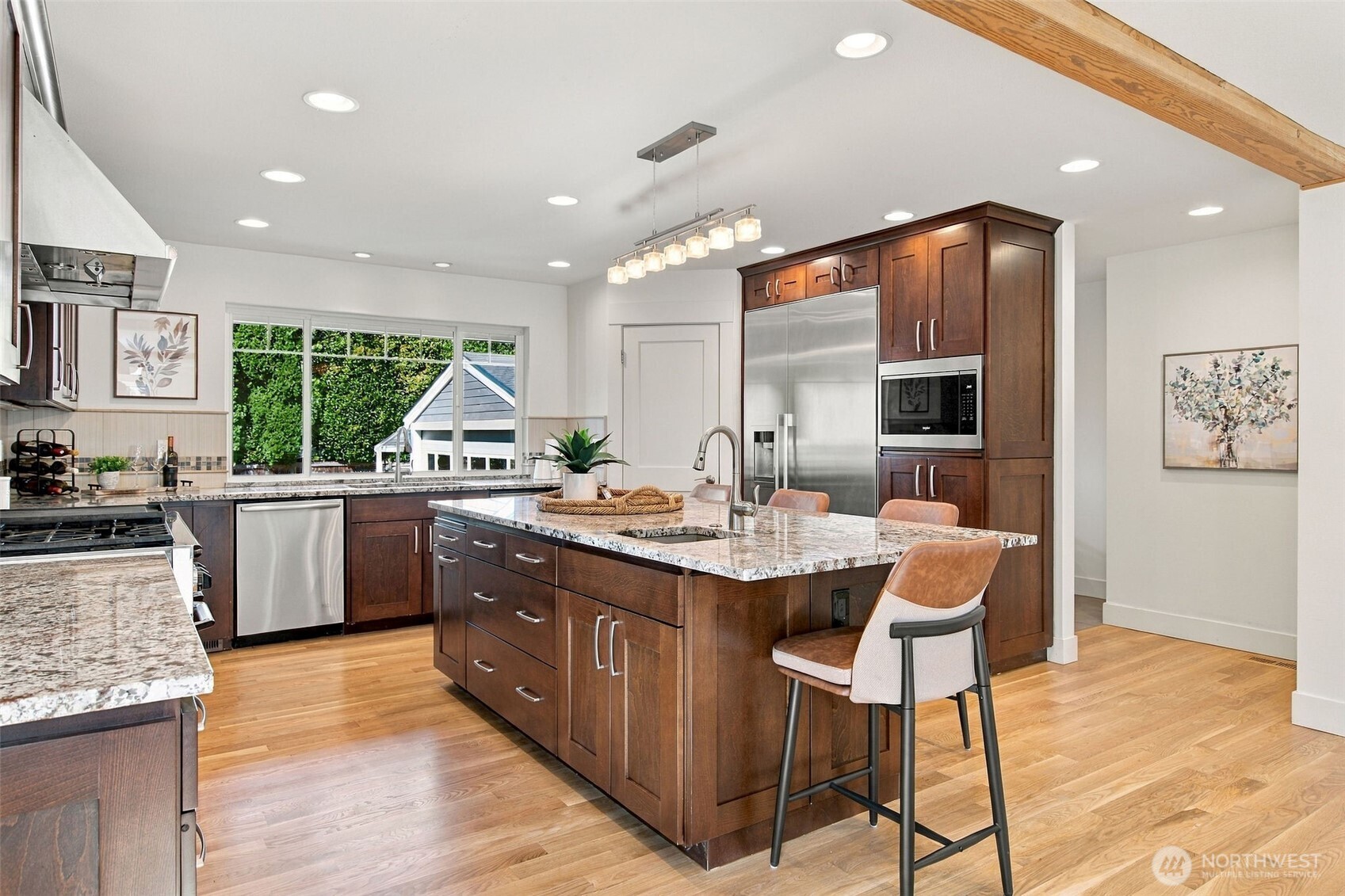 A generous island anchors the kitchen, with stainless appliances and garden views over the sink.