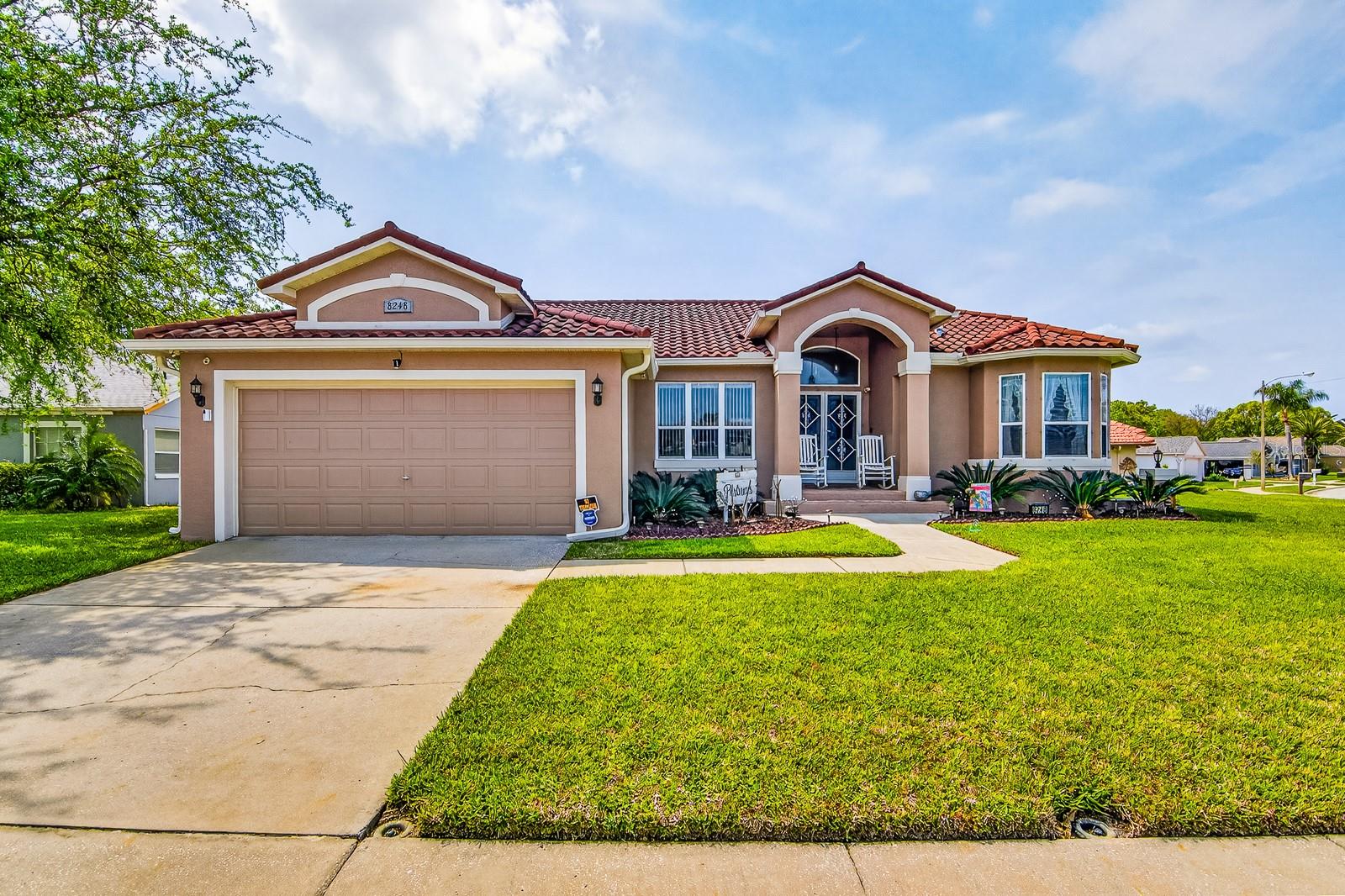 Welcome to Millwood Village, one of Beacon Woods’ most desirable enclaves, where quiet streets, mature landscaping, and low-maintenance living create the perfect Florida retreat. This beautifully maintained 3-bedroom, 2-bath, 1,714 sq ft pool home blends comfort, value, and lifestyle — ideal for active retirees, seasonal residents, and anyone seeking a move-in-ready home with exceptionally low carrying costs. With Fully Paid Solar you acquire a low to zero monthly electric bill! As you step inside you immediately notice the openness, the natural light, and the view straight out to the sparkling pool. Handscraped engineered hardwood floors carry through the dining and family rooms, adding warmth and character, while tile flooring in the kitchen and bathrooms keeps the home practical and easy to maintain. The kitchen is both functional and inviting, featuring granite countertops, medium-tone wood cabinetry, stainless steel appliances, a glass tile backsplash, and a breakfast bar. A custom-built table — designed to match the cabinetry and counters — anchors the breakfast nook and stays with the home, along with four bar stools. The split floor plan offers privacy, with the primary suite tucked away on its own side of the home. Here you’ll find tray ceilings, both a walk-in and standard closet, and an updated ensuite with double sinks, granite counters, a deep garden tub, and a floor-to-ceiling tiled shower with glass doors. Two additional bedrooms and a fully updated guest bath sit on the opposite side of the home, making the layout ideal for guests. Outdoor living is a highlight. The screened-in pool area features a newer screen enclosure (2022) with privacy panels, a covered lanai with room for both lounging and dining, and a peaceful backdrop of conservation behind the neighboring homes. Whether you’re enjoying morning coffee, hosting friends, or unwinding after a day on the golf course, this space delivers the Florida lifestyle buyers want. Major updates provide peace of mind and exceptional value: Tile roof (2015), HVAC (2015), Owned solar system (2022), Electric pool heater (approx. 3 years old), Exterior paint (approx. 3 years old), updated bathrooms, Newer Samsung washer & dryer in the laundry room with additional cabinetry and sink. Located on a corner lot within the Beacon Woods community, residents can enjoy a golf course, clubhouse, pool, and social amenities. The low HOA fees include cable, internet, trash, and community facilities. The neighborhood is well-maintained, quiet, and not in a flood zone. Just minutes to shopping, dining, medical facilities, Hudson Beach Park, and easy access to Little Road and US-19, this home offers the perfect blend of convenience and tranquility. This home is a well-cared-for pool home with a tile roof, owned solar, updated interiors, and a peaceful setting.