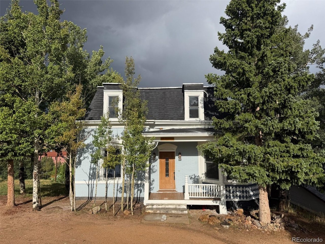 Full of historic character and thoughtfully updated for modern living, this charming Victorian home in Cripple Creek offers a unique blend of original character and modern comfort. Built in 1900, this two-story home features three bedrooms, three bathrooms, over 2,200 square feet of total space, and mountain and city views. The main level features natural wood flooring, a spacious living room, dining area with walkout access, and a functional kitchen with solid-surface countertops, center island, and breakfast bar. A convenient half bathroom completes the main level. Upstairs, all three bedrooms feature natural wood flooring, including the primary bedroom with an adjoining three-quarter bathroom, plus an additional three-quarter bathroom. The full walk-out basement offers approximately 575 square feet of additional space for storage, hobbies, or future possibilities. Outside, the wood deck provides a great place to enjoy the surrounding mountain views and peaceful setting. Located within walking distance of downtown Cripple Creek, you'll be close to shops, restaurants, and entertainment, while nearby vacant land adds to the sense of space and privacy. Whether you're looking for a full-time residence, mountain getaway, or investment opportunity, this home offers a distinctive piece of Cripple Creek history
