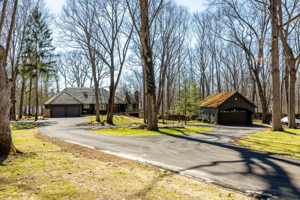 MULTIPLE OFFERS - BEST AND FINAL DEADLINE: Monday, March 16th, 2:00 pm. This stunning & elevated custom home enjoys a park-like setting w/majestic trees, sweeping lawns & panoramic lake views. The all-new driveway lends a stately approach to the home w/ample parking & large circular way to the distinctive ''covered bridge'' barn. This meticulously improved home boasts incredible outdoor living space w/ winding decks, multiple sitting areas & 3-season screened gazebo, all offering commanding views out to the tranquility & stunning beauty of Parks Lake. The heart of the interior is the exquisitely reimagined kitchen, w/its striking Symphony Stone center island & backsplash, Thermador range, SS appliances & fabulous butler's pantry for added storage, microwave cubby & prep sink. The floorplan for this gorgeous home is uniquely flexible-primary suites on the main & upper levels, laundry room on the main & lower level. Walk-out LL also enjoys guest/live-in amenities.