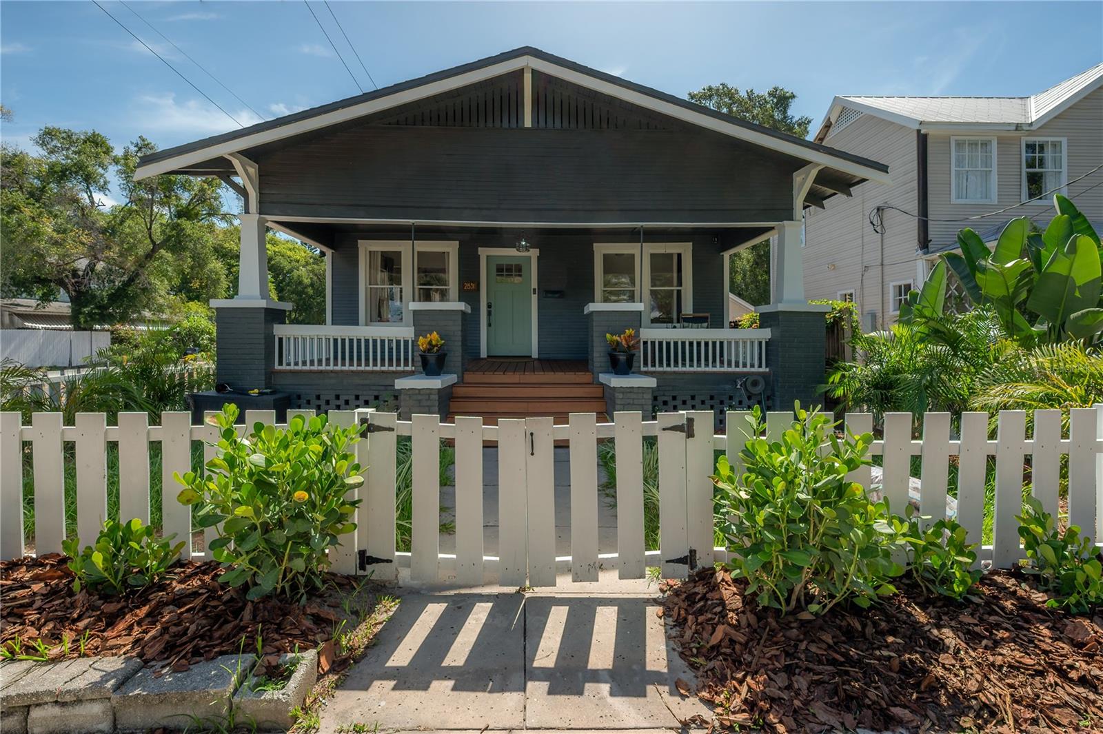 Meet Midnight Magnolia. A romantic 1924 bungalow, thoughtfully restored and reimagined in the heart of historic Tampa Heights. The best historic homes don't lose their character during a renovation; they become even more themselves. Inspired by its owner—a local florist with an eye for timeless beauty—Midnight Magnolia is a home where vintage charm, lush greenery, and layered design come together to create something unforgettable. Every room has been intentionally curated to feel warm, inviting, and effortlessly collected, blending natural light with rich, moody finishes to create a home that's equal parts timeless, cozy, and full of life. Positioned proudly on a corner lot in the heart of Tampa Heights' historic district, the home welcomes you with an inviting 260-square-foot front porch that encourages evening chats with neighbors, and slow weekends spent watching one of Tampa's most beloved neighborhoods come to life. Inside, sunlight pours through the abundance of original windows, highlighting rich original hardwood floors, vintage details, and carefully layered finishes that perfectly balance bright and moody. The home blends historic craftsmanship with modern comfort, preserving the details that give it soul while offering everything a homeowner needs. Original features including hardwood floors, charming fireplace, built-in shelving, authentic 5-piece Craftsman trim, wood paneled doors, vintage glass doorknobs, and a charming clawfoot tub have all been lovingly preserved, celebrating the home's nearly century-old history. Behind the scenes, nearly everything has been renewed. A comprehensive renovation in 2023 modernized the home while honoring its original character. Major systems were updated, and a new primary suite was added, creating a true owner's retreat complete with a large walk-in closet, dual-sink vanity, & tiled shower with frameless glass enclosure. A tankless water heater adds modern efficiency while complementing the home's historic charm. And the location is equally compelling. Located in one of Tampa's fastest-evolving historic neighborhoods, Midnight Magnolia places you at the center of billions of dollars of transformative investment. Just minutes away, Gasworx, a $1 billion, 50-acre mixed-use development, is transforming the connection between Downtown Tampa & Ybor City. Nearby, the $600 million Central City YMCA redevelopment and $800 million Robles Park transformation are reshaping the surrounding area with new residences, retail, parks, & community spaces. But one of the greatest luxuries of living in Tampa Heights isn't just what's coming—it's what's already here. Within about a mile, you'll find Armature Works, the Tampa Riverwalk, Downtown Tampa, Julian B. Lane Riverfront Park, award-winning breweries, neighborhood coffee shops, boutique fitness studios, locally owned restaurants, & everything from casual brunch spots to Michelin-recognized dining. Homes like Midnight Magnolia don't come around often. Rich in history, thoughtfully restored, filled with original character, and perfectly positioned in one of Tampa's most exciting neighborhoods, this is more than just a home—it's an opportunity to become part of the next chapter of Tampa Heights.