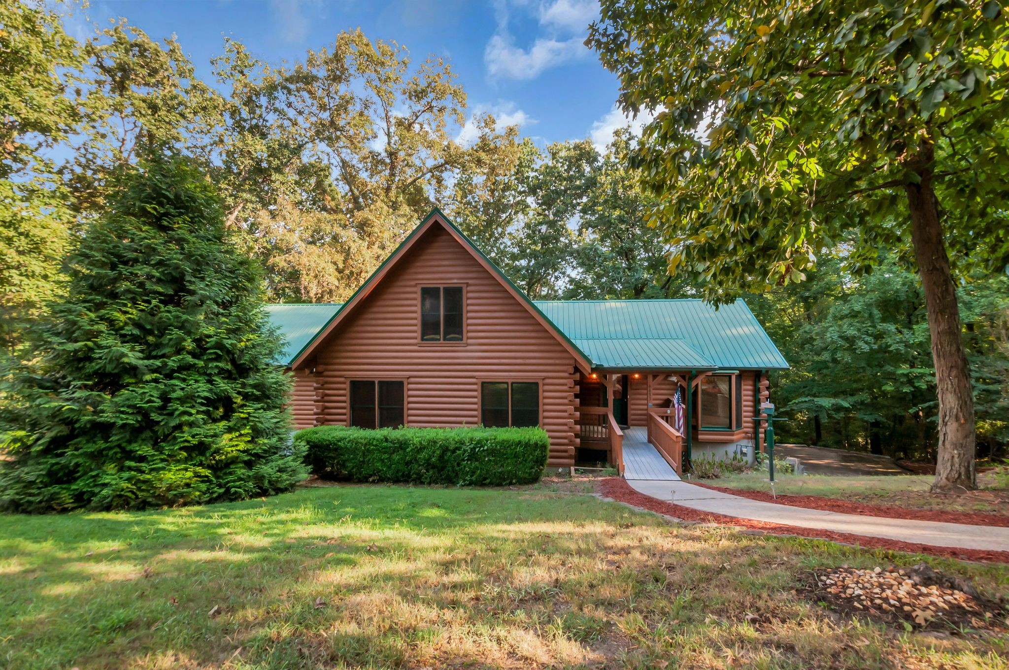 Authentic Log Home in Pegram with Exceptional Space for Entertaining! This solidly built Honest Abe Log Homes residence sits on 1.36 private acres in Tanglewood and offers approximately 3,477 sq. ft. of finished living space. Built from a custom plan using 8x8 milled D logs of Eastern white pine, this home has the character, warmth and substantial feel that makes a true log home so special.The 2,161 sq. ft. main level includes all 3 bedrooms and 2 full baths. The large primary suite features a walk-in closet and private bath with a jetted bath/shower combination. The great room features a gas fireplace & the kitchen includes a gas range & new microwave. Fresh paint, new carpet & a newly stained exterior give the home a fresh, well-maintained feel, while stacked log beams throughout add to its character.The 466 sq. ft. upstairs loft offers flexible space for an office, retreat or additional sleeping area. The finished basement adds 850 sq. ft. of entertaining space with a game room, wet bar, half bath, pool table & TV. The remaining basement area includes a 398 sq. ft. workshop with double doors leading to the carport & a 472 sq. ft. one-car garage.This home is made for entertaining! The main-level deck runs the length of the back of the home with large sitting areas on both ends, while the covered lower deck provides another large gathering area. Add the wet bar, game room, pool table, gas grill, & there is plenty of room for family and friends.The back of the home borders the woods, providing exceptional privacy. Additional features include a metal roof and the high-efficiency hydronic heating system that utilizes a commercial-grade Polaris stainless-steel water heater to provide comfortable forced-air heat through the home's central ductwork. Washer/dryer, four outdoor security cameras, gas grill, extra water heater, pool table & game-room TV remain. A truly special log home with exceptional character, privacy & spaces that makes entertaining fun & easy.