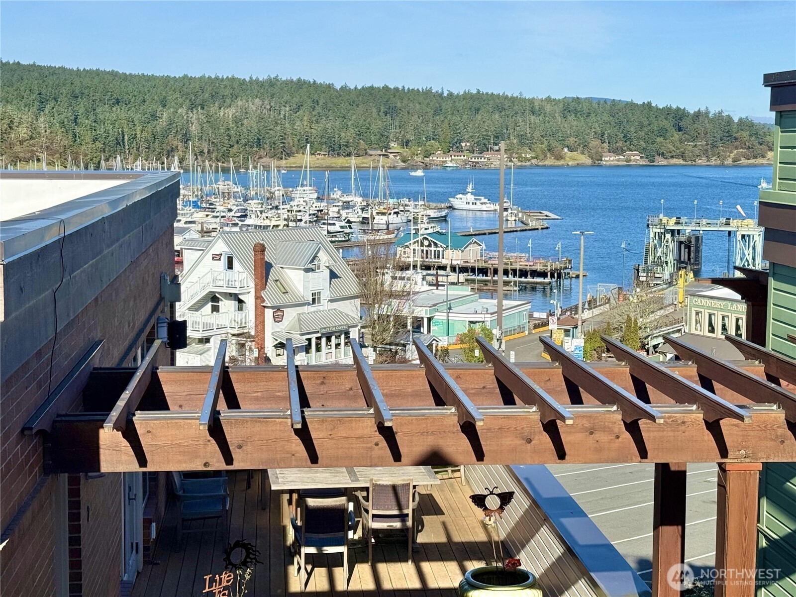 Live where the action is in the vibrant core of Friday Harbor! Just steps to the marina, ferry, restaurants, and shopping, this beautifully remodeled 1,628 sq ft condo offers the perfect blend of luxury, comfort, and convenience. Nightly rentals are allowed in the complex.  Enjoy views of the harbor, ferry arrivals, seaplanes, and boating activity from the roof top deck.   The open-concept living space features a dramatic floor-to-ceiling marble tile propane fireplace and abundant natural light.  The chef’s kitchen is designed to impress with stainless steel Bosch appliances, induction range, generous eat-in island, quartz countertops, and marble backsplash. Two spacious bedrooms and two full baths include a stunning primary suite with vaulted ceilings, spa-inspired 5-piece bath with dual sinks and soaking tub, and a walk-in closet with custom built-ins. Mini-split heat & A/C ensure year-round comfort. The unit was completely remodeled in 2024 with new flooring, carpets, appliances, kitchen cabinets, countertops, lighting fixtures, a marble tiled fireplace, a bidet toilet, and decking on both decks.   Secure coded entry, elevator access, and dedicated parking for your island car in a secure garage provide convenience and peace of mind.   Move-in ready, including furniture, and perfectly positioned in the heart of San Juan Island — enjoy effortless island living with harbor views.  As the unit can be a VRBO, you can enjoy tax advantages as well as some personal use.