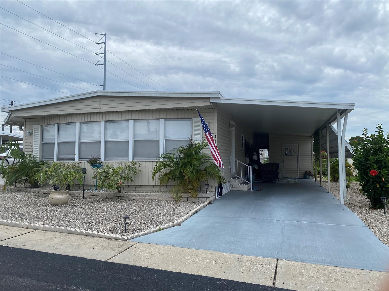 Welcome to paradise! A fully furnished, double wide mobile home in one of the most desirable locations in Pinellas County.... Dunedin! This beautiful turn key coastal home features an open floor plan.
The interior features updated luxury vinyl plank flooring throughout. The modernized kitchen features granite countertops, under cabinet motion lights, dishwasher and stainless steel appliances. There is a pass through bar from the kitchen to the living room. The dining room hutch has a granite top as well. Both bedrooms are very roomy with lots of closet space. The master bedroom features an in-suite bathroom with a walk in shower. The living area boasts a spacious dining/living room area with lots of windows that brings in lots of light. Included in the updated is new ceiling fans, light fixtures, goose neck faucet in the kitchen and granite countertops in both bathrooms. Shiplap and bead board has been added as accents to enhance the coastal theme of the home.
The shed area includes a washer and dryer and plenty of space for storage! The lot is beautifully landscaped with a privacy fenced patio in the rear. The home has vinyl siding for energy efficiency along with a newer water heater (1 year old) and a newer HVAC unit that is approximately 3 years old. This coastal home includes an ownership share in the community which gives you low monthly fees of $160 per month.
