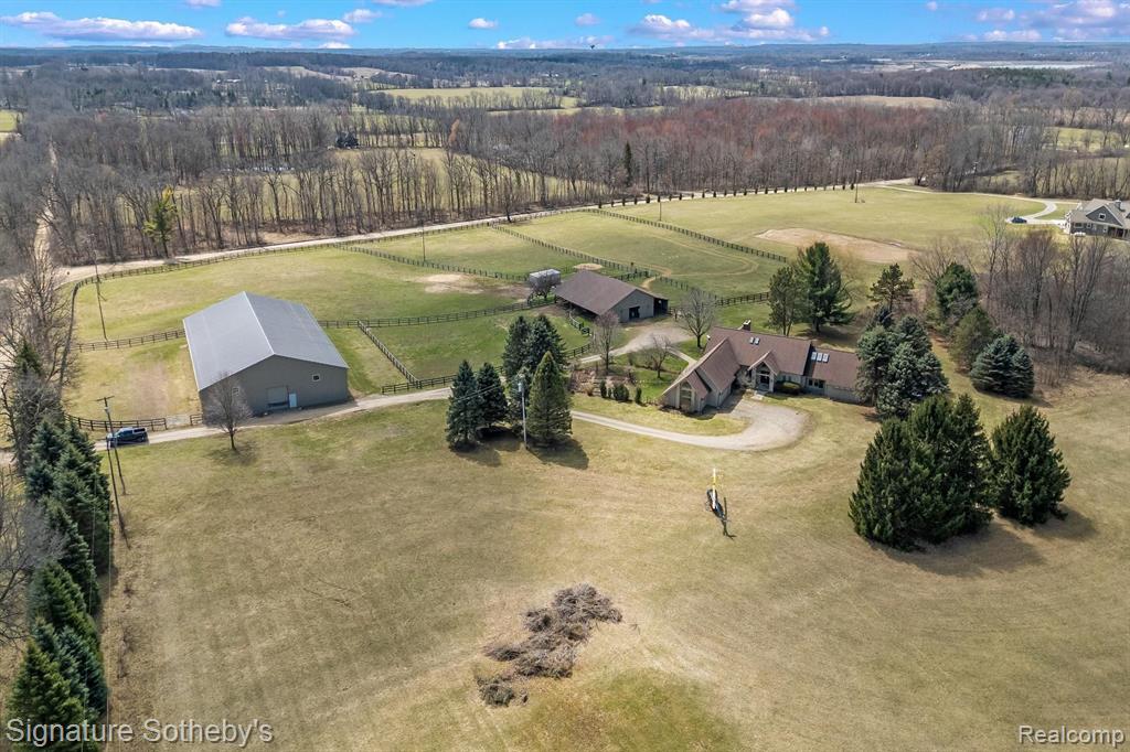 Just minutes from town and top-rated schools, this exceptional equestrian estate offers an unparalleled blend of luxury and functionality for the discerning horse enthusiast. Every detail has been thoughtfully designed to provide both comfort and practicality for country living.  At the heart of the property is a state-of-the-art barn featuring seven stalls, including a spacious birthing stall, a dedicated wash stall, a well-appointed tack room, and a convenient feed room. The barn is complemented by an 80 x 140 indoor arena—perfect for year-round riding—situated alongside three large paddocks and one smaller paddock near the arena. Run-in sheds in every pasture ensure your horses enjoy 24/7 shelter and comfort. Additionally, we’ve recently installed a brand-new well pump and pressure tank, ensuring reliable water access for all your needs. The sunlit, move-in-ready home is as inviting as it is functional, offering breathtaking views of the surrounding landscape. The interior boasts maintenance-free flooring ideal for farm life, a large laundry room complete with a dog-specific bathtub, and a fenced-in dog yard—perfectly accommodating both human and furry family members. Indulge in the spa-like primary bathroom, relax in the hot tub, or enjoy the cozy ambiance of the fireplace after a day on the farm. With geothermal heating, ample hay storage, and the potential to harvest your own hay, this meticulously maintained property offers an unparalleled opportunity for sustainable, luxury living in a serene equestrian setting. See attached plans for further details.