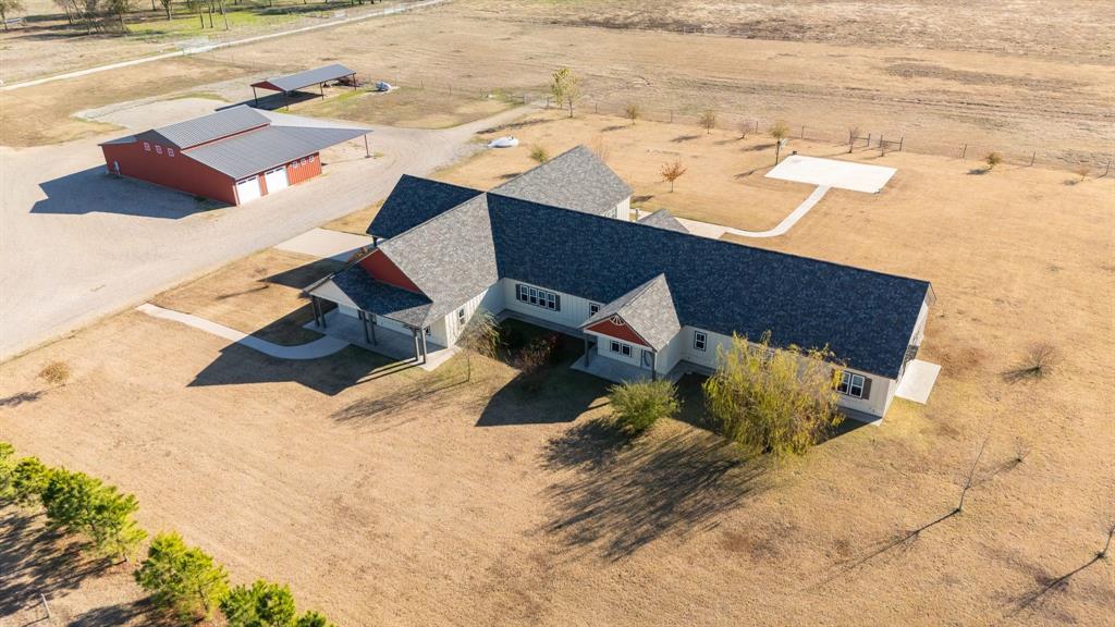 With a landscaped entry & security gate, this 6 bedroom 6 bath Custom Home is designed and built for a large family or flexible family living & entertaining! Built with modern touches -10' ceilings, crown molding, recessed LED lighting, custom roll up shades, quartz countertops, ex-large bedrooms, double vanities in baths, tiled walk in showers & more! This unique design centers two separate wings around the 2 kitchen areas & a massive dining area & entertaining area where the windows provide plenty of natural light as well as a wood stove. The kitchens feature quartz countertops, island, gas stoves, double ovens, 2 refrigerators, double pantries, buffet kitchenette & more. The master bedroom features his & her baths with double closets and overhead storage system as well as a coffee bar, sink & private porch. The 5 large bedrooms all have custom closet system with additional overhead storage. The baths have double vanities, 2 with tubs & 2 with tiled showers. Plenty of space & storage in all baths. 2 utility rooms with the offering a sink, quartz folding table, washer & dryer hookups and plenty of room for freezers and refrigerators. The landscaped yard has a wide range of bushes, shrubs and a variety of trees with custom irrigation system. Also in place, a large capacity concrete storm shelter. Backyard has extended concrete patio & concrete basketball court ready to enjoy! The 75x75 metal shop has foam insulation, concrete, electric, water, 6 roll up doors, storage room, generator hook up, overhead storage, half bath and covered parking. A 50' metal equipment shed for covered parking. This area is surrounded by graveled parking area for large equipment, RV or trailers. Plenty of good fencing & cross fencing with several pastures (Bermuda, Clovers & Rye grass), small paddocks with water, 2-50x50 metal barns, 25x75 metal barn, 3 pond and seasonal creek provides surface water in pastures. Easy access to DFW, Paris & Sherman makes this perfect for a Corporate Retreat