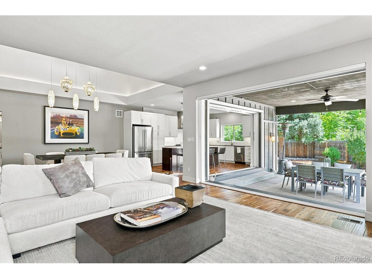 Custom Luxury & Modern Craftsmanship in University Hills. *Seller will consider a substantial concession for a temporary rate buydown with acceptable offer.* Built in 2018, this spectacular custom ranch delivers the design, systems, and craftsmanship of true new construction - main floor primary suite and seamless indoor-outdoor living, tucked away on a quiet residential lot. Perfect for those desiring single-level living, with walking distance to the High Line Canal and Eisenhower Park. This architectural work of art delivers premium finishes throughout. The kitchen is thoughtfully scaled with high-end custom wood cabinetry, a quartz island with bar seating, and stainless appliances, flowing into a light-filled, open-concept dining and living space. Step through the home's defining luxury feature: disappearing glass walls that instantly erase the distinction between indoors and the Colorado outdoors, opening to a private covered outdoor living room and a striking geometric patio perfect for year-round entertaining. The main level features a private, sanctuary-like primary suite with a spa-inspired 5-piece bath and an oversized walk-in closet. Just off the entry, two additional main-floor rooms with a Jack-and-Jill bath make ideal home offices, a studio, or flex space - ready to work from day one, ideal for anyone who wants their workspace nearby rather than tucked away. Downstairs is a true second living level, not just a basement: 9'+ ceilings, abundant natural light, 3 additional bedrooms, 2 full bathrooms, a spacious family room, and convenient kitchenette - exceptional for multigenerational living, a guest or in-law suite, or simply spreading out, with storage to spare. Enjoy nearby Wellshire Golf Course, Ross Library, and University Hills and Happy Canyon shopping & dining, with easy access to I-25 and Light Rail keeping all of Denver within reach. For neighborhood features click on Tour 2. For a drone fly-through of this amazing home click on Virtual Tour.