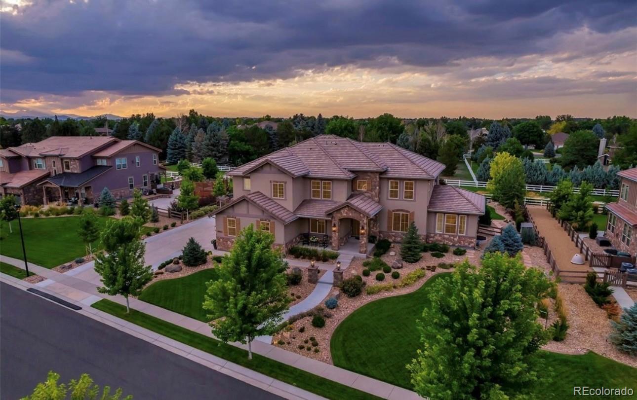 Welcome to this exceptional Lambertson Farms residence, perfectly positioned on a landscaped greenbelt lot offering over 6,400 finished sq ft. A grand entry opens to formal living & dining rooms filled with natural light. The main floor features a private office with French doors, laundry/mud room, & a guest suite with sitting area & 3/4 bath, ideal for multigenerational living, long-term guests, or a private retreat. The chef's kitchen features premium appliances, oversized island, walk-in pantry, pendant lighting & eat-in area. The kitchen flows seamlessly into the vaulted family room with fireplace, wall of windows, electric shades & greenbelt views. Formal living & dining rooms provide additional gathering space, while the dining room opens directly to the covered patio, creating excellent indoor/outdoor flow for entertaining. Upstairs, the primary suite offers a sitting area, 3-sided fireplace, 5-piece bath & walk-in closet. Two secondary bedrooms share a Jack-and-Jill bath & feature walk-in closets, while an additional bedroom includes its own ensuite bath & walk-in closet. The finished basement features high ceilings, large rec room, wet bar, workout room, powder bath, abundant storage & a private 6th bedroom with ensuite 3/4 bath. The backyard backs directly to the greenbelt & community trail system with walking & biking access to the neighborhood pool, parks & McKay Lake. Enjoy Colorado outdoor living from the large, covered patio featuring a built-in grill, refrigerator, fire pit & private hot tub with TV viewing area. With no homes directly behind, the greenbelt setting provides a rare combination of privacy, views & recreation right outside your back door. Additional highlights include an oversized 3-car garage with epoxy floor, 2 backyard storage sheds, mature landscaping, extensive outdoor living space & convenient access to Denver, Boulder, DIA, shopping, dining, golf & top-rated schools. One of Lambertson Farms' most desirable greenbelt locations.