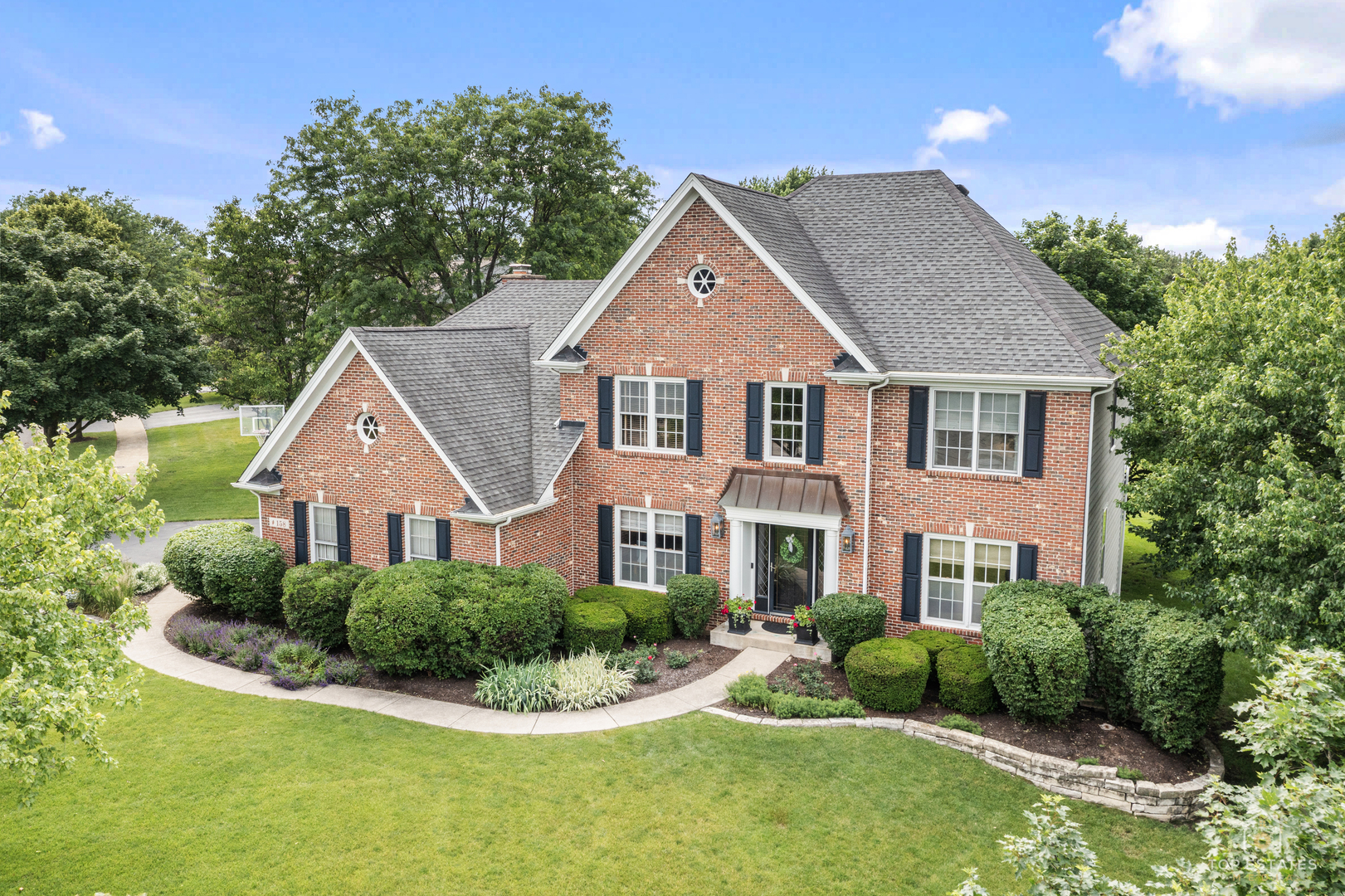 This stately brick and cedar residence with exceptional updates is truly a Glen Ellyn showpiece! Timeless elegance blended with modern sophistication and located in the heart of desirable Derby Glen! This impeccably maintained home has gone through multiple custom designed transformations! Home boasts numerous renovations thoughtfully planned and executed by professional interior design firms. The stunning kitchen serves as the centerpiece of the home, featuring custom cabinetry, quartz countertops, a large center island, designer lighting, and new high-end stainless-steel appliances. Abundant prep space and storage make everyday living effortless, while the open layout is perfect for entertaining. The kitchen flows seamlessly into the spacious eating area and dramatic family room, where vaulted ceilings, skylights, and a striking floor-to-ceiling brick fireplace create an inviting atmosphere. Formal living and dining rooms with gleaming hardwood floors provide elegant spaces for hosting family and friends, while the private first-floor office with custom built-in cabinetry offers an ideal work-from-home setting. Rich hardwood flooring, quality millwork, and tasteful decor enhance the home's warmth and character throughout. A grand two-story foyer welcomes guests with a sweeping staircase and impressive architectural details. Upstairs, the luxurious primary suite offers a true retreat highlighted by a remarkable spa-inspired bath renovation. Completely redesigned down to the studs, the space features heated Italian Carrara marble floors, extra-wide custom vanities, a one-of-a-kind oversized marble shower, freestanding soaking tub, Visual Comfort nickel chandelier and sconces, crown molding, new windows, and custom tiled closets. The hall bath has also been beautifully updated with a tiled shower, glass enclosure, vanity, flooring, and fixtures. Additional improvements include a remodeled powder room, updated lighting, and new hardwood flooring in the office and second-floor hallway. The finished basement offers exceptional living space, complete with a 5th bedroom, full bath, dedicated study area, and spacious recreation room. A three-car garage provides ample room for vehicles, hobbies, and family storage needs. The list of improvements continues with major mechanical updates including a brand new water heater (2026), air conditioner and thermostat (2024), 2 new sump pumps, and a Generac whole-house standby generator. Furnace replaced in 2012. Complete tear-off roof replacement completed in 2009. Step outside and enjoy your own backyard oasis. Situated on a professionally landscaped lot with exceptional curb appeal, the expansive covered deck overlooks a serene yard filled with mature trees, colorful gardens, and lush landscaping. The deck awning has been recently replaced and professionally maintained, creating a comfortable outdoor living space perfect for relaxing or entertaining. From the beautiful curb appeal and thoughtfully updated interior to the outstanding outdoor setting, this home reflects years of pride in ownership and meticulous care. A rare opportunity to own one of Derby Glen's finest residences, offering timeless style, exceptional craftsmanship, and true move-in-ready condition.