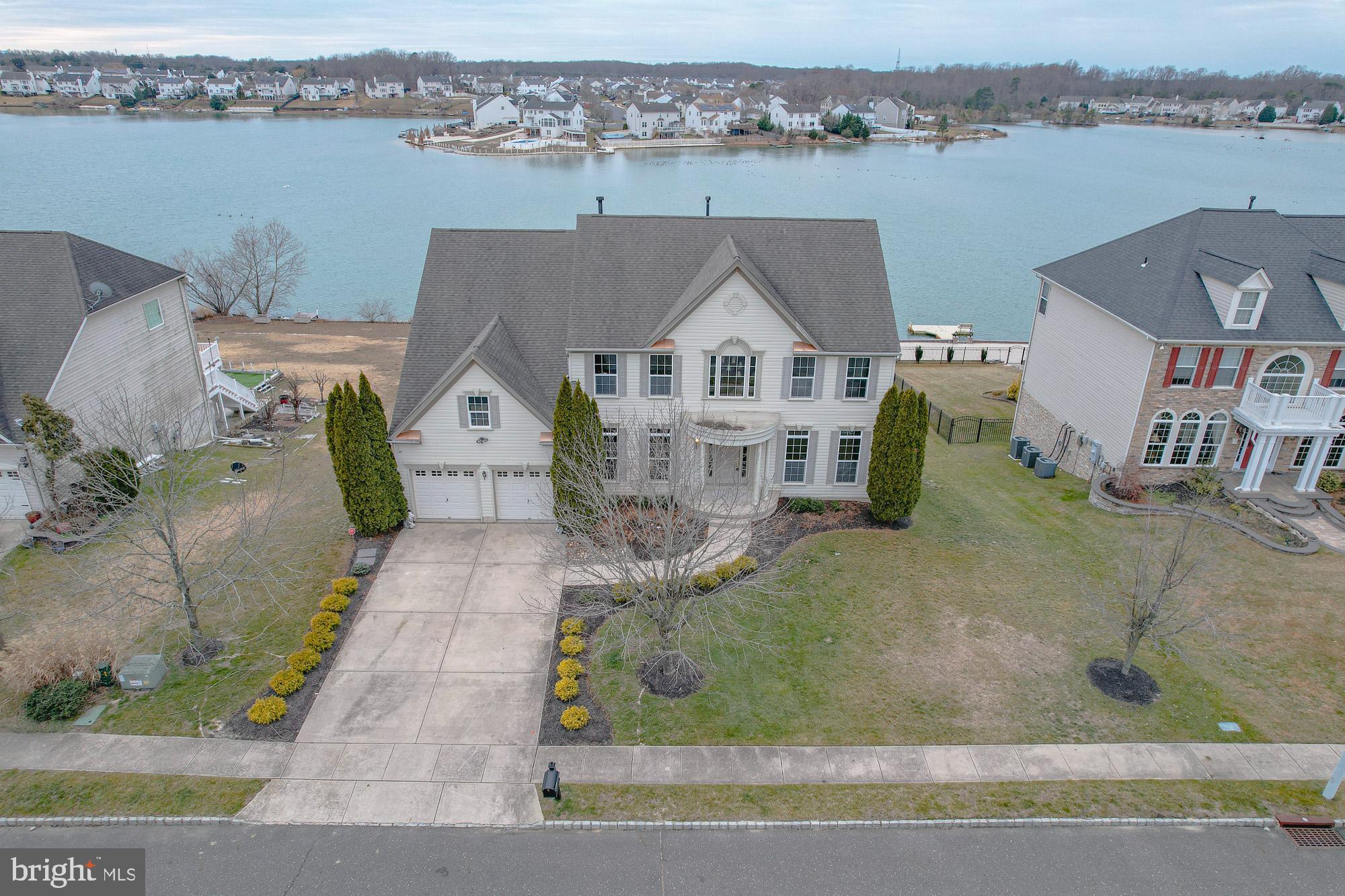 Exquisite Lakefront Residence in Lakeside at Cobblestone. Experience refined waterfront living in this exceptional Middleburg model, ideally situated on a premium lakefront lot in the highly sought-after Lakeside at Cobblestone community. Offering 4 bedrooms and 2.5 baths, this elegant home combines timeless design with breathtaking lake views. A grand two-story foyer with hardwood flooring and a sweeping staircase creates a striking first impression. The formal living and dining rooms, positioned on either side of the entry, provide an ideal setting for upscale entertaining and intimate gatherings. The expansive family room features hardwood floors, a gas fireplace, and walls of windows that capture panoramic views of the crystal-blue lake, creating a seamless connection between indoor comfort and natural beauty. The chef’s kitchen is thoughtfully designed with 42" custom cabinetry, a center island, double ovens, a butler’s pantry, generous storage, and a sunlit breakfast area. Sliding doors lead to a spacious Trex deck, perfect for outdoor dining while enjoying serene lakefront vistas. The primary suite offers a private retreat with a sitting area, two walk-in closets, and a spa-inspired bath featuring a jacuzzi tub and walk-in shower. Tranquil lake views complete this luxurious sanctuary. Three additional bedrooms on the upper level are generously sized with ample closet space. The walkout lower level boasts impressive 12-foot ceilings and is ready to be finished to suit your vision—ideal for additional living space, recreation, or a home theater. Step outside to a lakeside patio and enjoy direct access to year-round waterfront living. A rare opportunity to own an elegant lakefront home offering comfort, sophistication, and an exceptional setting. Enjoy an easy commute to Philadelphia, Delaware, Cherry Hill, the Jersey Shore and more! Very close to Shopping and many dining options. The Premium Outlets are only 4 miles away.