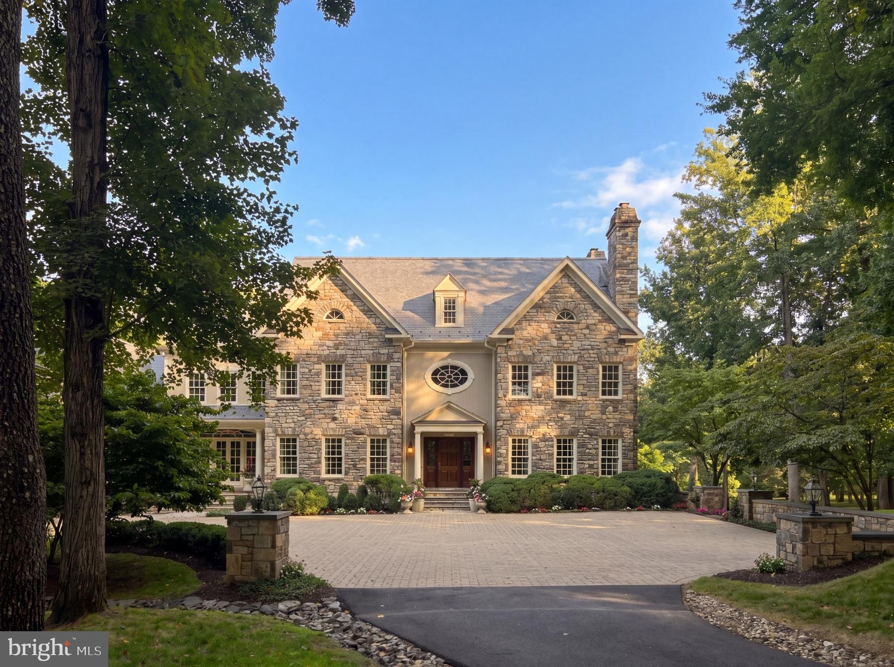 Set within five private acres in one of Great Falls's most coveted enclaves, 558 Innsbruck Avenue is an extraordinary custom estate where remarkable scale, enduring craftsmanship, and a waterfront setting on Arnon Lake create a residence of uncommon presence. A sweeping driveway winds through the grounds before arriving at the custom-cut-stone home. Originally constructed by master builder George Sagatov, renowned locally for estates of enduring quality, the residence spans 14,700 finished square feet, balancing grandeur with an atmosphere that remains warm, inviting, and deeply connected to its surroundings.The three-story foyer immediately establishes the architectural character of the home. Floating staircases rise through a dramatic volume exceeding 30 feet in height, framed by custom wrought-iron railings reflecting three generations of artisanship. From this central gathering point, the principal living spaces unfold with a natural progression and sense of occasion. Embassy-sized formal rooms are grand in scale and rich in millwork, harkening back to a bygone era of hand craftsmanship. A wood- and leather-paneled library offers an intimate counterpoint, opening to a private second-floor terrace overlooking Arnon Lake. The double-height great room shifts the scale toward relaxed living, with soaring coffered ceilings, a floor-to-ceiling stone fireplace, and expansive water views.At the heart of the informal living spaces, the gourmet kitchen is designed for both serious culinary pursuits and sophisticated entertaining. A generous walk-in pantry provides substantial storage, while a dedicated butler's pantry creates a discreet connection between the kitchen and dining room. Beyond, a breezeway leads to the showstopping sunroom, where a sophisticated layered ceiling draws the eye upward and walls of windows pull the landscape and water views deep into the home, creating an effortless transition between interior and exterior living.Each bedroom is conceived as a private suite complete with a full bath and walk-in closet. The lavish primary suite includes a dressing room designed in the style of a luxury boutique, with illuminated built-ins and dual islands, alongside a spa-like marble bath. A centralized upper-level retreat provides gathering space, while the third floor introduces a dedicated conference room, bunk room, separate recreation room, and flexible spaces that allow the upper level to function as a destination unto itself.The walk-out lower level transforms recreation into an experience of its own. A substantial paneled bar and step-down recreation and game rooms are arranged in Sagatov's trademark style, with soaring ceilings and abundant natural light. A state-of-the-art home theater is tucked away, while the wellness wing includes a fitness center and steam room. A cabana with its own bar area offers a more casual, pool-centric setting, connected to the sunroom above by a custom spiral staircase.Beyond the interiors, the estate's relationship with its setting becomes especially compelling. Covered porches, balconies, terraces, and patios extend the architecture into the landscape, creating numerous vantage points from which to experience tranquil Arnon Lake and the property's mature surroundings. The swimming pool and waterfront establish the rear grounds as a private retreat, with more than 200 feet of shoreline lending a serenity rarely found this close to Washington. A broad motor court and four-car garage complete a residence designed for everyday life and grand-scale entertaining with equal ease.For all its extraordinary dimensions and amenities, 558 Innsbruck Avenue is defined less by any single grand gesture than by the cumulative effect of its architecture, setting, and thoughtful sequence of spaces. Room after room, level after level, the estate reveals another layer of its character, creating a private Great Falls sanctuary where remarkable scale is balanced by uncommon intimacy.