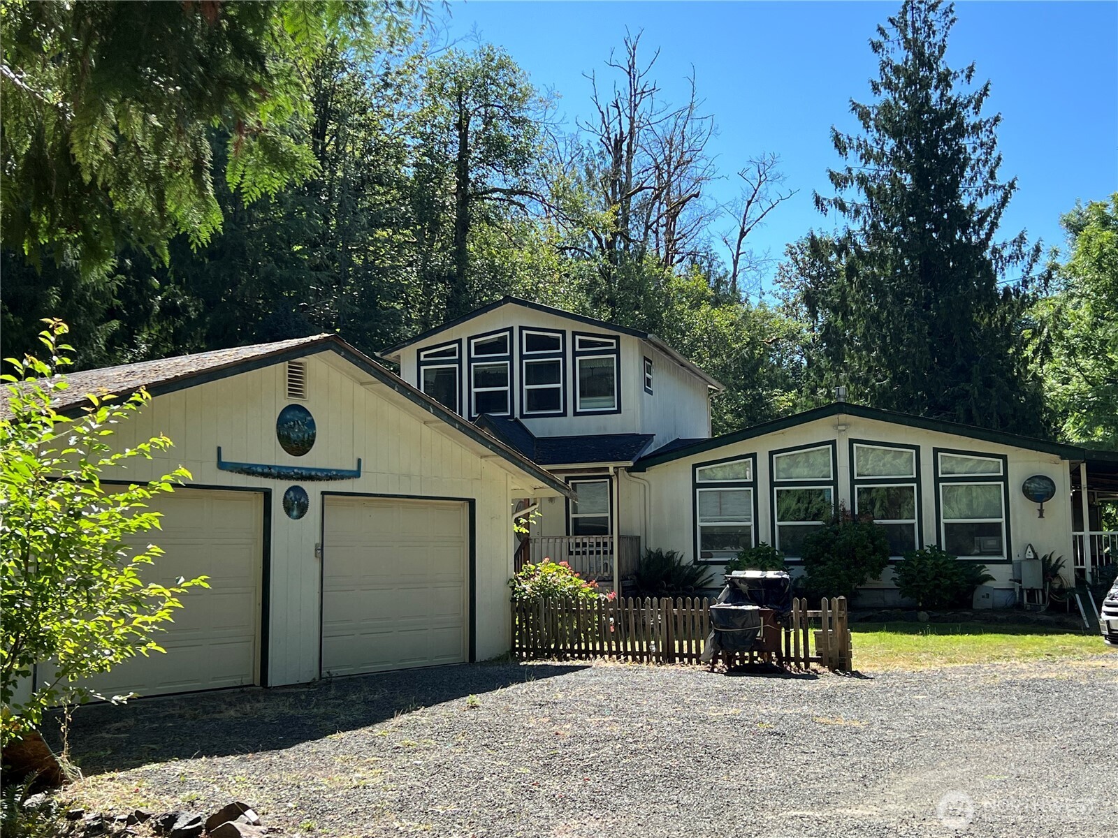 The river at this beautiful home nestled on almost five acres is the focal point of relaxation. This property features a  spacious two bedroom manufactured home with a large second story stick-built add-on. The island kitchen offers plenty of  storage as well as a pantry and a dining room with a beautiful chandelier. The large upstairs room could be a spacious  third bedroom or a bonus room for your projects. The double garage is at the end of the circular driveway and has an  additional living space, which could be developed into a small apartment, hobby space or woodworking. Check out the  gazebo and firepit overlooking the Tilton river and enjoy the shade of the wraparound porch. Located only 3 miles from  downtown, this is a great get away property, Airbnb potential. Ample parking and lots or potential for a private  swimming/fishing hole! Lots of mature shrubs, perennials and trees here, bring the tools and resurrect the landscaping.