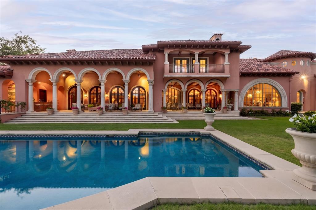 Escape to a world where the golden age of Palm Beach architecture meets modern-day opulence. This hidden 12.8-acre Mediterranean sanctuary, inspired by the legendary Addison Mizner, is a 12,872 sq ft testament to a life of curated elegance. A winding, tree-lined private drive welcomes you into a lifestyle defined by artisanal heritage and luxury. The home’s aesthetic reflects a symphony of rare materials: limestone columns, hand-carved mahogany doors, and masterful Cassi Plaster ceilings. In the formal living room, Bordeaux wood floors glow under the light of a spectacular chandelier, while an arched window offers a cinematic view of the private one-acre pond. The great room creates the ultimate stage for the host, featuring cypress-beamed ceilings and a magnificent Parisian chandelier. Evening parties are hosted around the wet bar, complete with a wine room and built-in draft. A seamless transition of the expansive limestone veranda continues outside, featuring a stunning hand-painted mural that says “The Good Life” in Latin. Culinary pursuits await in the gourmet kitchen, where London-inspired frescoes and cast-stone surround a suite of SubZero, Viking, & Gaggenau appliances. A butler’s pantry ensures every gala executes with precision. The primary wing is an enclave of indulgence, where hand-painted ceilings and a fireplace lead to his & hers retreats adorned with beautiful marble floors. For the fashion connoisseur, two expansive walk-in closets and a two-story walk-in cedar closet provide a gallery-like space for any collection. Conveniently located in the next room is your home gym. Outside, the estate feels like a private European resort. Spend afternoons by the lap pool and spa, entertain with the wet bar, or wander through lush gardens to the greenhouse. For the automotive collector, a finished 20-car garage complex with lifts and a full living quarters awaits. A full-size guest house also resides on the grounds.