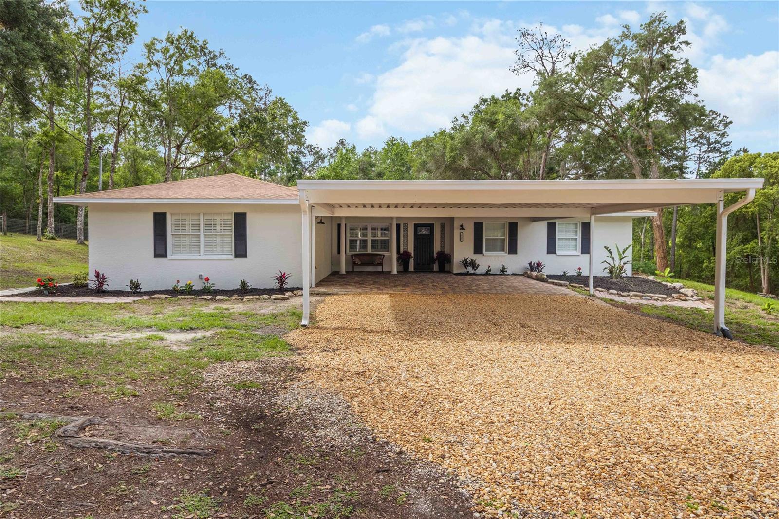 Welcome to your private retreat at 2293 Spring Lake Hwy in Brooksville! Situated on 2.5 acres, this beautifully remodeled home offers the perfect balance of space, privacy, and modern comfort. With approximately 2,360 square feet of living space, this 3-bedroom, 2-bathroom residence also includes a spacious bonus room and an additional flex space—ideal for a home office, guest area, media room, or hobby space—providing versatile living options to suit a variety of needs. Set back from the main road, the property offers a quiet, low-traffic setting, creating a peaceful country atmosphere while still maintaining convenient access to nearby conveniences—approximately 10–15 minutes to downtown Brooksville and about 20–30 minutes to Wesley Chapel’s shopping, dining, and retail destinations. The home has been thoughtfully updated throughout. The kitchen has been renovated with updated quartz countertops and appliances, while both bathrooms have been refreshed. Luxury vinyl flooring runs throughout the home, complemented by fresh interior and exterior paint, along with updated landscaping, creating a clean, modern feel from the moment you arrive. Built in 1990, the home features a roof installed in 2016 and an HVAC system replaced in 2023. A central vacuum system adds everyday convenience. A rear screened-in lanai provides a comfortable outdoor space to relax and enjoy the surrounding property. Outdoors, the property truly stands out. With no HOA, you have the flexibility to store your boat, RV, or other recreational vehicles. The expansive 2.5-acre lot offers plenty of room to spread out and enjoy, and includes an additional structure that can be used as a workshop or for storage of equipment and tools. The workshop features a loft/attic area with a convenient pull-down ladder, as well as a utility sink located on the rear exterior of the structure. A fenced enclosure—previously used as a goat run—offers versatility for pets, livestock, or other outdoor uses, supporting a flexible rural lifestyle. A charming swing in the front yard adds to the property’s appeal, offering the perfect spot to relax and take in the peaceful surroundings. If you’re looking for a move-in ready home with land, privacy, and room to grow, this property presents an exceptional opportunity.