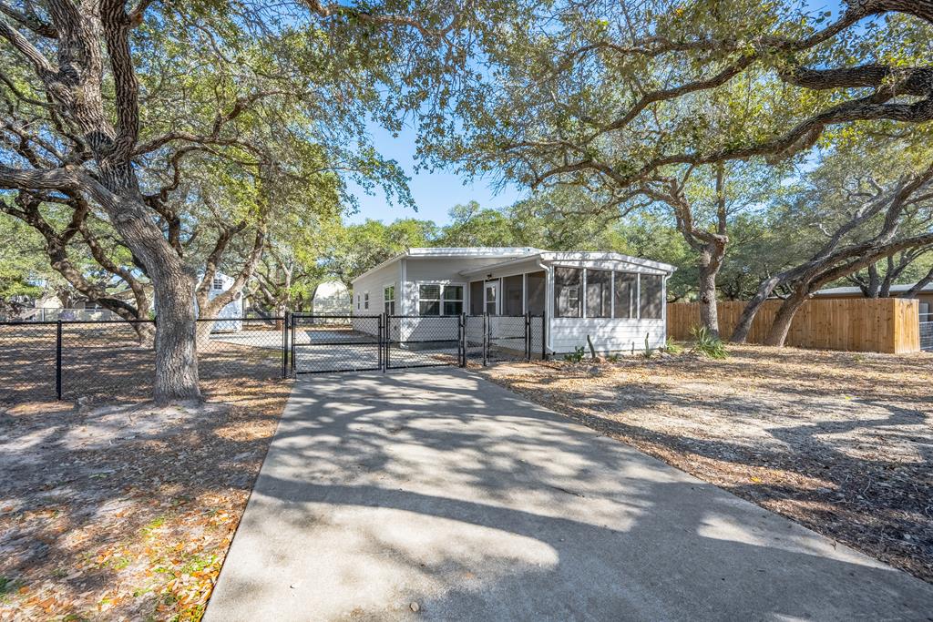 Tucked beneath the shade of towering coastal live oaks, this charming Lamar Peninsula retreat sits on two fully fenced, spacious lots and captures everything possible people love about the laid-back coastal lifestyle.  Originally updated in 2019, the home blends comfort and character with inviting spaces designed for relaxing after a day on the water.  The spacious open concept kitchen was thoughtfully updated with new cabinetry, granite countertops, and modern appliances, offering plenty of room to cook up the day's fresh catch.  The giant screened-in porch is the true star of the show - perfect for slow morning coffee, breezy afternoon naps, or sunset cocktails as the coastal sky lights up over Lamar.  The generous lot size gives you plenty of room for your boat, fishing gear, and coastal toys, and a new shed provides great extra storage.  Located just minutes from Goose Island State Park, your surrounded by some of the best fishing, birding, and hunting on the Texas Coast.  Spend your mornings chasing Redfish, afternoons exploring the trails and shorelines as Goose Island, and evenings enjoying the restaurants, art galleries, and charm of nearby Rockport.  Whether you're looking for a weekend fishing retreat, vacation getaway, or full-time coastal escape, this property offers the space, shade, and location to enjoy the very best of the Lamar Peninsula lifestyle.