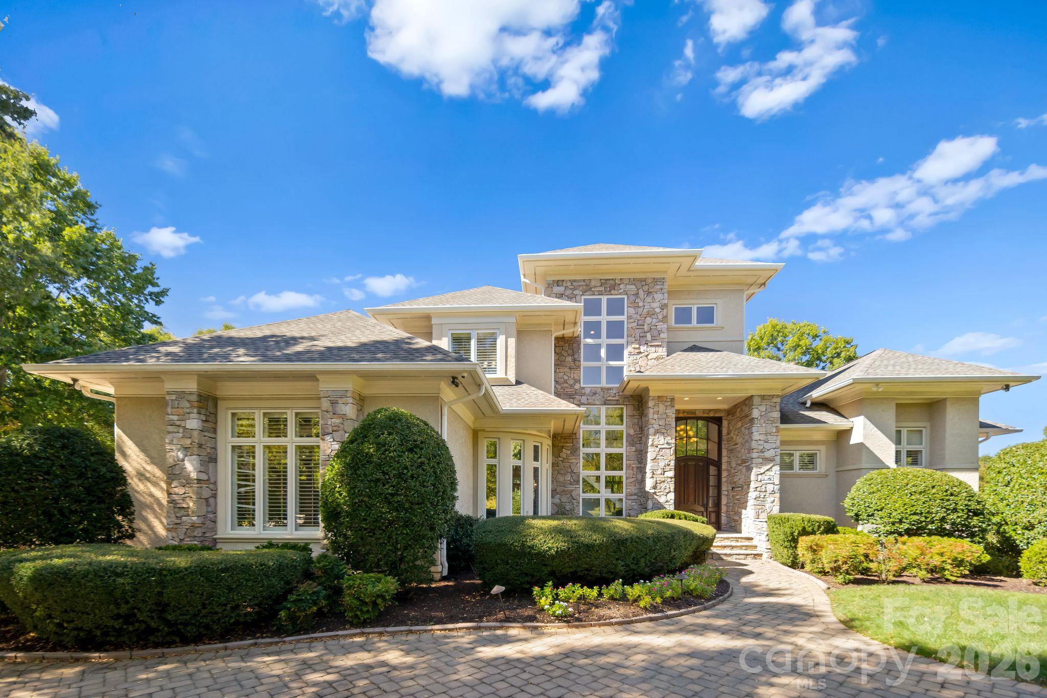 Skip the five year wait. This Simonini built show home in Ballantyne Country Club comes with an equity golf membership available for transfer, bypassing the club’s five-year waitlist (transfer fee paid directly to the club). That alone makes it rare. The house makes it one of a kind.Inspired by the organic architecture of Frank Lloyd Wright, the home sits on a private cul-de-sac lot backing to the 16th tee box, with over 7,700 square feet designed for the way people actually live. The soaring foyer sets the tone the moment you walk in. Curved walls, generous windows and natural light throughout. This is a house that photographs well, but has to be walked to be understood.The primary suite is on the main. The kitchen anchors the floor plan with real scale and function, opening to casual living and dining that flow right outside. Upstairs, three more bedrooms each have their own ensuite bath, plus a built-in office and cedar closet.The walkout basement is where this home separates itself: rec room, wet bar, billiards space, dedicated media room with tiered seating, exercise room, wine room, a fifth bedroom and full bath. An entertainer’s floor plan top to bottom.Outside, the pool, spa, new fire pit area, and mature tree canopy deliver the privacy you’d expect from a cul-de-sac on the course. A three-car garage, paver driveway, and mature landscaping complete the arrival.The big-ticket items are handled: 2019 roof, HVAC/Furnaces replaced in 2018, 2019, 2020 and 2024, and whole-home air purification added in 2025. The hard work is done. Bring your vision and your golf clubs.