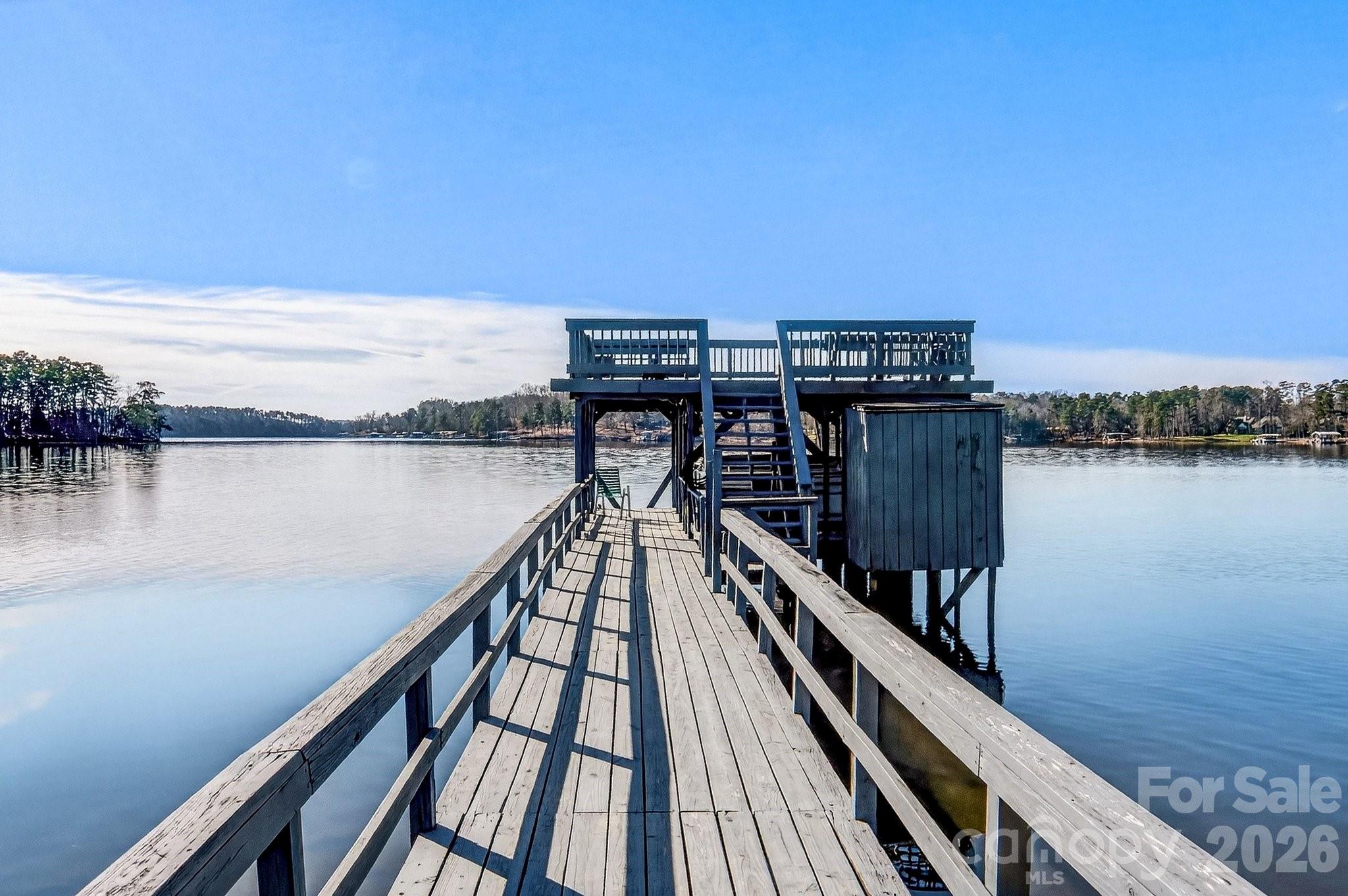Discover the ultimate Badin Lake getaway at this exceptional lake house, where breathtaking water views greet you from every angle.  Nestled along the pristine shores of Badin Lake - North Carolina's hidden gem with 5,350 acres of sparkling water, abundant wildlife, and proximity to Uwharrie National Forest - this rare property boasts a grandfathered double-decker dock with boat lift, offering unparalleled convenience for boating, fishing swimming and relaxing on the water. Step into the spacious, welcoming double patio porch - perfect for morning coffee with sunrise views, family barbecues, or even gatherings as the sun sets over the lake. The thoughtful design maximizes those incredible 365 degree panoramas while providing easy, stair-free access to the water's edge - ideal for multi-generational families, retirees or anyone seeking effortless lake living. Much of Badin Lake's shoreline can be steep and sloped  but this home has a walk out basement with zero stairs to the water's edge. On the main level you'll find two cozy bedrooms, full bath and living/kitchen flooded with natural light and commanding sweeping lake vistas that make everyday feel like a vacation. Downstairs is a versatile walkout level featuring a large room that can be used as a bedroom, full bath, laundry room and comfortable living room space where the double sliding doors open directly to the lakeside patio - seamless indoor/outdoor flow for entertaining or quiet relaxation. With North Carolina's  supportive framework for vacation rentals and Badin Lake's growing appeal a outstanding vacation destination, this home offers excellent income potential - whether as a weekend retreat, family legacy spot or lucrative Airbnb/VRBO investment. Schedule your private tour today and see why Badin Lake living (and investing) is so rewarding. (Interior photos & measurements to come)