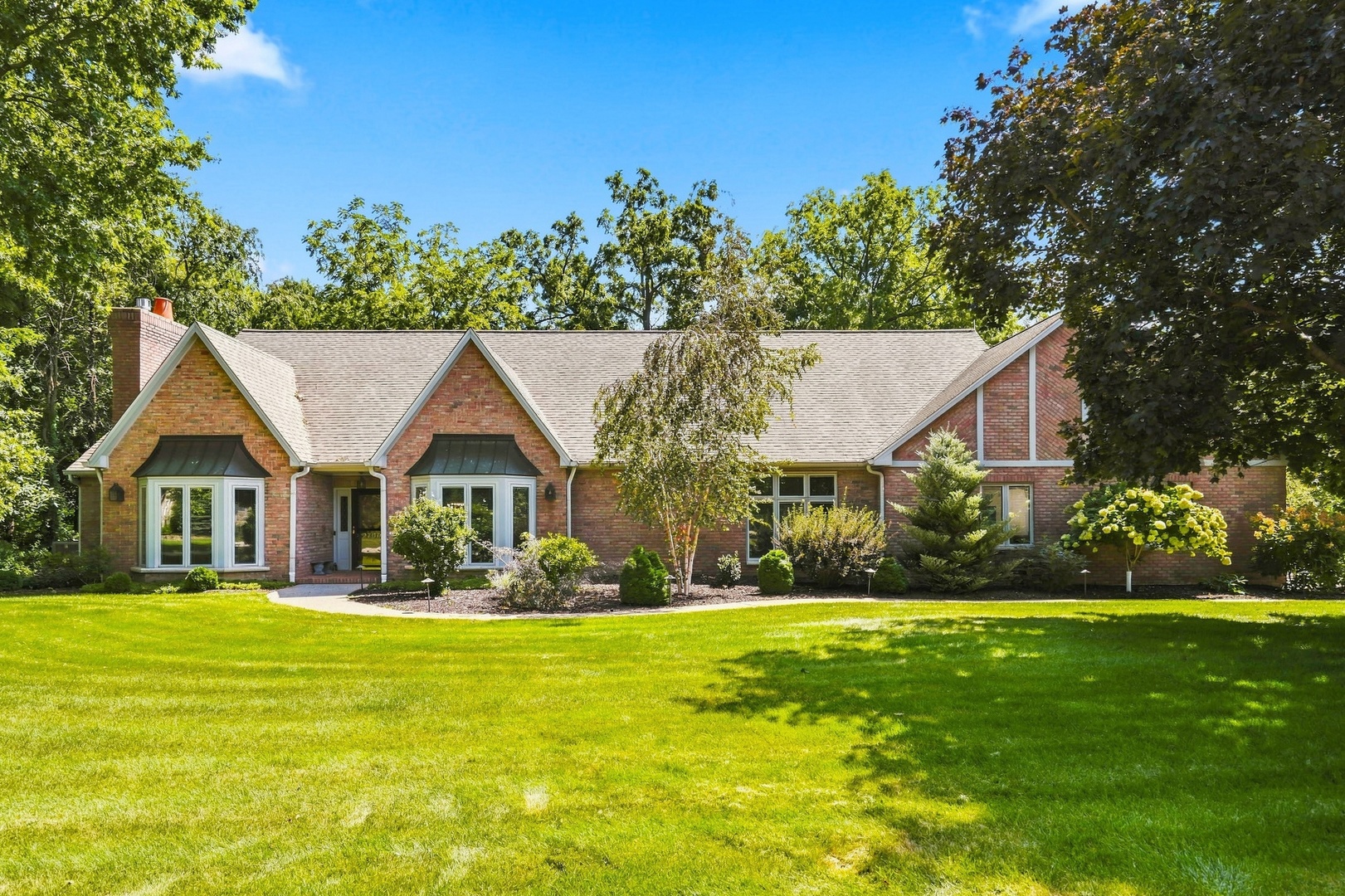 Tucked into Callaway Court on a private, nearly three-quarter-acre lot surrounded by mature trees, 2700 11th Street Court offers spacious single-level living in Moline, Illinois. Built by Warner Paulsen, this impressive four-bedroom, 4 bath brick ranch combines classic architecture, generous living spaces, and thoughtful updates.  The main level features beautiful hardwood details, spacious gathering areas, a dedicated home office or den, a four-season room overlooking the property, and convenient main-floor laundry. The kitchen offers abundant cabinetry, stainless steel appliances, and plenty of room for everyday meals and entertaining. The primary suite includes a private bath with heated floors and a walk-in closet, while newer interior paint creates a fresh, updated feel throughout the main level.  The recently finished basement significantly expands the home's living space with a fourth conforming bedroom with an egress window, a full bath, a large recreation area, and a bar. This versatile lower level offers exceptional flexibility for entertaining, overnight guests, hobbies, or additional everyday living space.  Additional features include a three-car heated and cooled garage with water and a trenched floor drain, a whole-house generator, balcony and patio spaces, and mature landscaping. With substantial finished living space, a flexible floor plan, and the privacy of a nearly three-quarter-acre corner lot, this Warner Paulsen-built brick ranch offers an exceptional combination of space, character, and functionality in one of Moline's tucked-away settings.