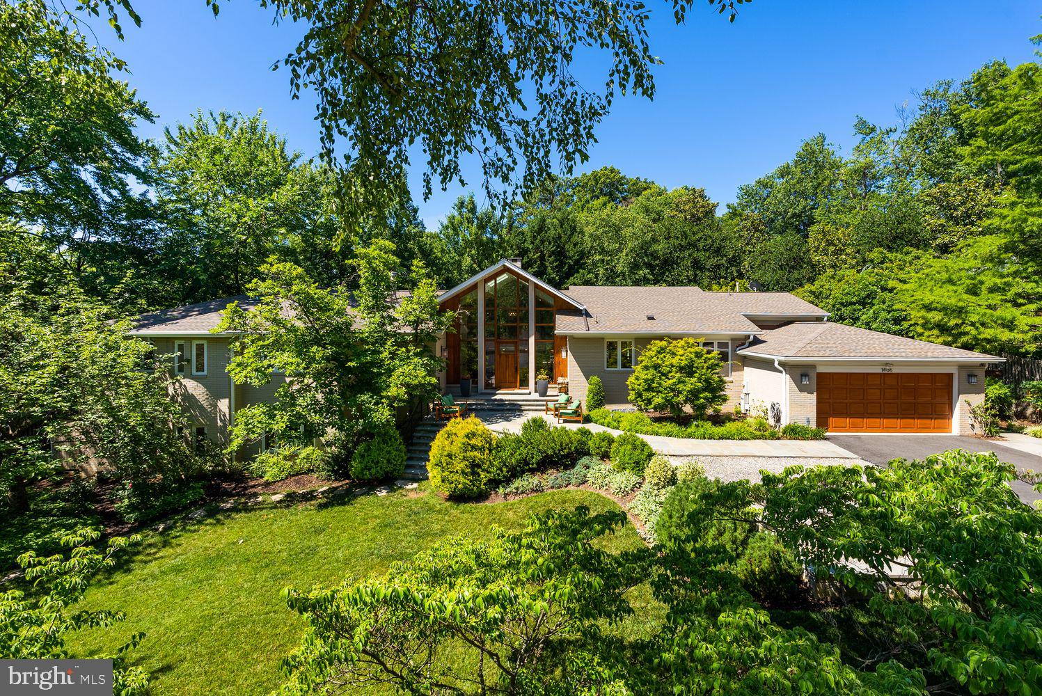 BROKERS OPEN HOUSE this Wednesday, 9/9, 11:30 - 1:30. Some homes make a statement. Others make you feel at home the moment you arrive. Few achieve both. Tucked behind a long private approach and surrounded by nearly one-half acre of meticulously landscaped grounds, this one-of-a-kind residence offers a rare combination of striking architecture and effortless livability. Thoughtfully reimagined through an extensive renovation, every space has been designed to welcome natural light, showcase exceptional craftsmanship, and create a seamless connection between indoor and outdoor living. Expansive walls of windows, soaring wood-clad ceilings, exposed structural beams, reclaimed wide-plank hardwood floors in warm natural tones and custom millwork create an architectural character that is both sophisticated and inviting. Sunlight fills nearly every room while framing tranquil views of the pool, terraces, and mature gardens. A dramatic glass-and-timber entry welcomes you into the heart of the home, where the great room is anchored by a handcrafted stone fireplace with copper accents—a space equally suited for quiet evenings by the fire or memorable gatherings with family and friends. The chef's kitchen is as beautiful as it is functional, featuring premium appliances, designer lighting, an oversized island, abundant custom cabinetry, and thoughtfully concealed storage that keeps everyday living beautifully organized. A custom entertaining bar with wine storage, beverage refrigeration and ice-maker makes hosting effortless. Designed for the way people live today, the home offers inviting rooms for every occasion, including multiple conversation spaces, a sun-filled office lined with custom built-ins, a private den, a generous mudroom, and flexible transitions that easily adapt to work, relaxation, or entertaining. The four-bedroom, three-full and two-half-bath floor plan is highlighted by a serene primary suite featuring a spa-inspired bath, an oversized walk-in shower, and an expansive custom dressing room. Outside, the home becomes its own private retreat. Expansive stone terraces surround the saltwater pool and tranquil waterfall, flowing naturally to a fully equipped outdoor kitchen with stainless steel appliances, generous prep areas, and bar seating for ten beneath a dramatic pergola. An outdoor shower, fire pit terrace, and multiple gathering spots invite everything from lively summer celebrations to peaceful evenings under the stars. Mature landscaping, exceptional privacy, and tranquil water views create the feeling of a boutique resort, yet restaurants, shopping, and everyday conveniences remain just minutes away. Additional highlights include a two-car garage, integrated smart home technology, a whole-house generator, and countless custom details that reflect the exceptional craftsmanship found throughout the home. More than simply a beautiful house, this is a home designed to bring people together—to celebrate holidays, entertain effortlessly, enjoy quiet moments, and create lasting memories for years to come.