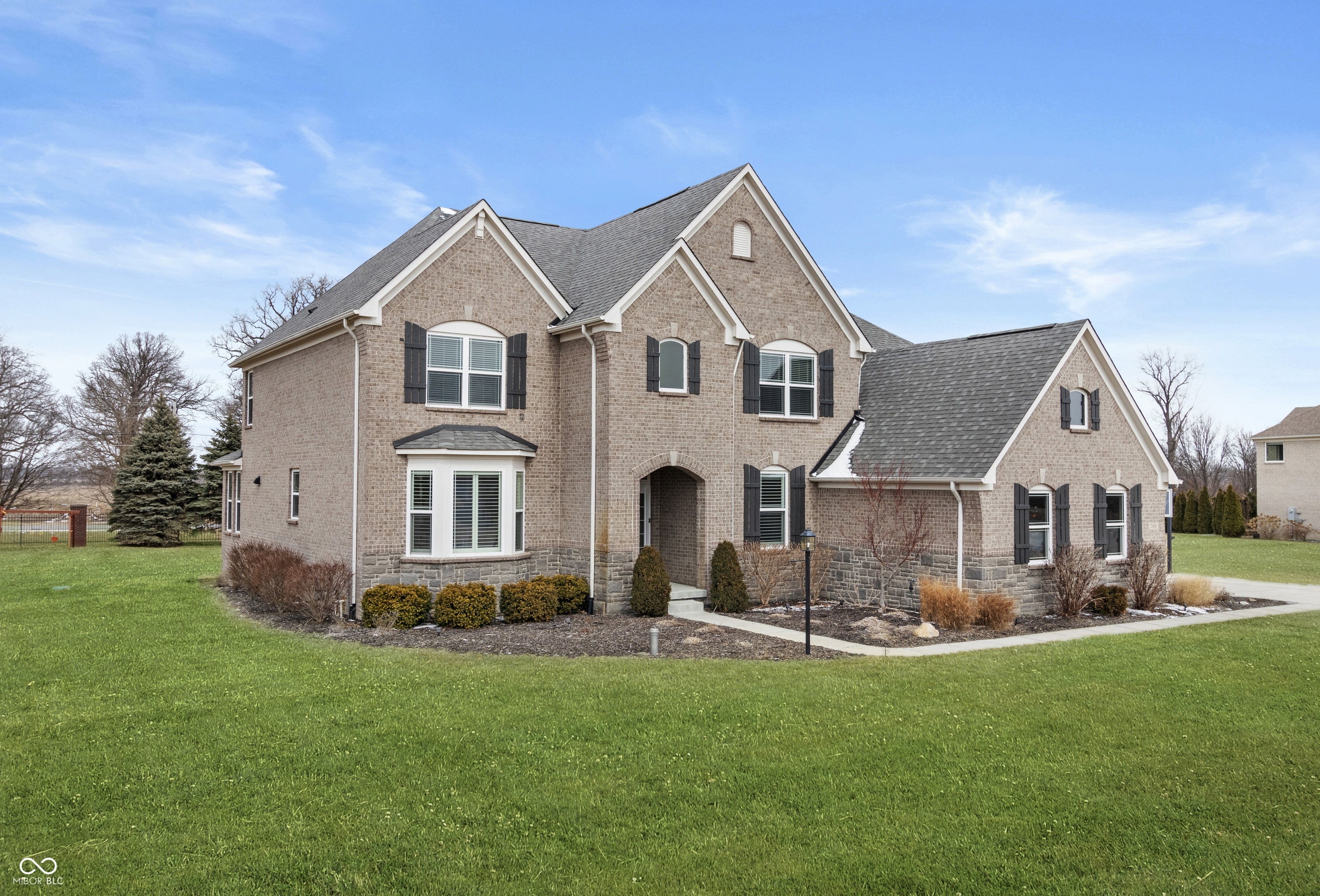 Welcome to refined living in Kennesaw, Brownsburg's premier estate neighborhood. This stunning two-story home makes an unforgettable first impression with a dramatic, light-filled entry and an open-concept floor plan designed for both everyday comfort and elegant entertaining. Engineered hardwood floors, expansive windows, and thoughtful architectural details create a warm yet sophisticated atmosphere throughout.    Offering 5 bedrooms and 5.5 baths, this home provides exceptional space and flexibility. A main-level bedroom with en-suite bath is ideal for guests or multi-generational living. The impressive finished basement features daylight windows, a full bath, dedicated storage, an exercise area, and plumbing in place for a future bar-perfect for entertaining on any scale.    Upstairs, you'll find a spacious loft, a dedicated craft or study area, a convenient second-floor laundry room, and generously sized bedrooms. Two secondary bedrooms share a well-appointed Jack-and-Jill bath, while the luxurious primary suite serves as a private retreat with dual vanities, dual walk-in closets, a deep soaking tub, and an oversized walk-in shower with dual shower heads.    The gourmet kitchen is a chef's dream, showcasing stainless steel appliances, a wine cooler, and an expansive breakfast bar ideal for gathering. A functional mudroom connects seamlessly to the oversized four-car garage, offering both practicality and ample storage.    This exceptional property blends luxury, comfort, and thoughtful design in one of Brownsburg's most sought-after communities.