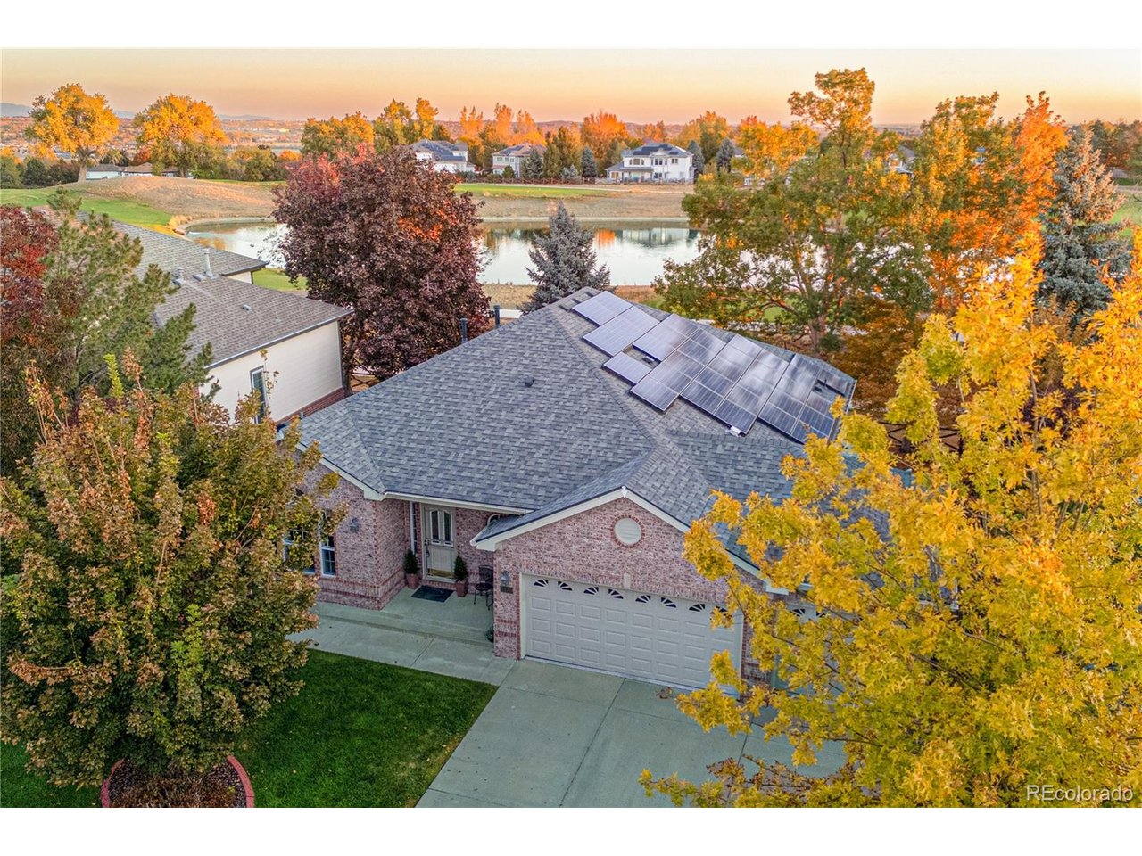 Experience one of Legacy Ridge's most desirable settings from this beautifully maintained ranch overlooking the pond and 7th tee of Legacy Ridge Golf Course. This home offers nearly 3,500 finished square feet and exceptional main-floor living, with three bedrooms-including the spacious primary suite-on the main level. Walls of windows bring the golf course and water views indoors, while hardwood floors, high ceilings, fresh paint and abundant natural light that create a bright open feel especially through the new windows. The kitchen is designed for everyday living and entertaining with new flooring, a center island, generous cabinetry, built-in double ovens, new microwave, new induction cook top, breakfast nook and adjoining great room with fireplace. The primary suite enjoys peaceful views, a bay-window sitting area and private five-piece bath. Downstairs, the expansive daylight basement feels like a second living level with a family room and fireplace, game/recreation space, wet bar with wine refrigerator, two additional bedrooms, 3/4 bath and an impressive private office with built-in desk, bookcases and shelving. Step outside to the expansive deck and take in the pond, fairway, sunsets and mountain views, with additional garden and sitting areas below. The oversized three-car garage features epoxy flooring, cabinetry and workspace. Extensive improvements over the years include high end window replacements, updated flooring, upgraded kitchen and baths, new LG washer and dryer, finished basement, deck, garage improvements, concrete landscape borders, HVAC work and hail-resistant roofing. Solar adds another compelling benefit: seller-provided Xcel records show an average payment of approximately $116 per month over the most recent 12-month period, and the solar is to be paid off at closing per seller. Golf-course living, water and mountain views, ranch-style convenience, abundant finished space and a premier Legacy Ridge location.