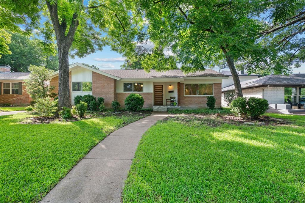 Tucked away in coveted Lochwood neighborhood, this exquisite 3-bedroom, 2-bath home offers the perfect blend of modern updates and tranquil living. New HVAC in 2022. Just minutes from Downtown Dallas and the scenic White Rock Lake, you'll enjoy the best of both worlds — city convenience with the peace and privacy of a nature-rich setting. Nestled among mature trees and backing to a lush greenbelt, this home feels like a true retreat. Step inside to find spacious, light-filled interiors featuring gleaming hardwood floors throughout. The thoughtfully updated kitchen is a chef’s dream, boasting new granite countertops, a large island with gas cooktop and oven, pristine white cabinetry, and a decorative tile backsplash. The open-concept layout flows effortlessly into a generous dining area that could easily double as a secondary living room. Anchored by a striking floor-to-ceiling stone fireplace, it's a warm and welcoming space ideal for entertaining or relaxing. The expansive primary suite is your personal sanctuary, complete with a fully renovated spa-like bathroom, an oversized walk-in shower, and a custom walk-in closet offering both style and functionality. Two additional guest bedrooms feature hardwood floors and share a beautifully updated bathroom with dual sinks, floating vanity, and chic circular mirrors. Step outside to enjoy a large, beautifully maintained backyard and a covered patio — perfect for morning coffee or evening gatherings. Whether you're unwinding at home or heading out for a lakeside jog, this home offers a rare connection to nature without sacrificing location. Don't miss your opportunity to own a piece of paradise in Lochwood — schedule your tour today! HAVE YOUR AGENT SEND YOU THE PROPERTY VIDEO IN THE VIRTUAL TOUR LINKS.