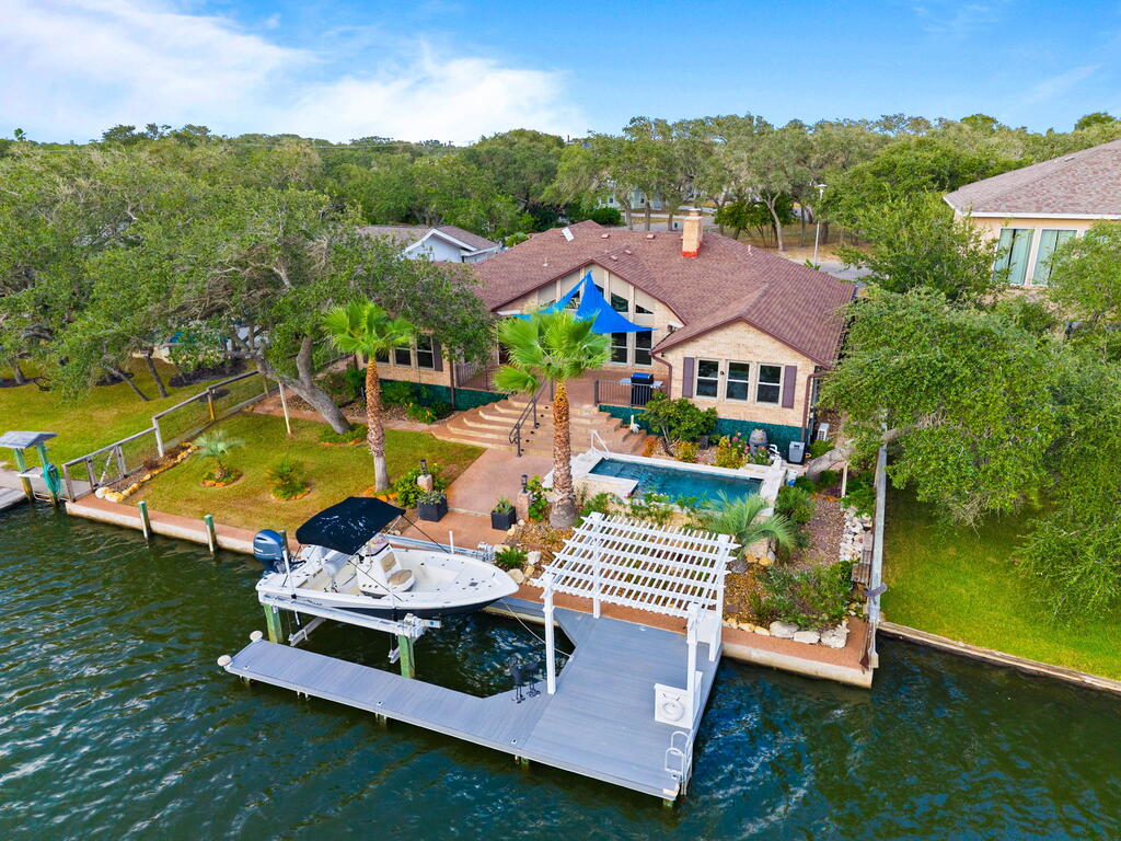 Welcome to an extraordinary waterfront retreat in the exclusive Harbor Oaks subdivision, where luxury, thoughtful design, and an exceptional coastal lifestyle come together. Extensively remodeled in 2021–2022, this beautifully appointed, single-level home offers over 2,800 sf with 4 bedrooms, 3 baths and 3-car garage. From the moment you enter, soaring cathedral ceilings and a dramatic wall of windows draw your eye to spectacular waterfront views, creating a light-filled and inviting setting designed for both elegant entertaining & everyday comfort. At the heart of the home is an impressive chef-inspired kitchen featuring striking granite countertops, custom cabinetry, generous eat-in bar and breakfast area, all opening beautifully to the dining & living spaces. Luxury vinyl plank flooring flows throughout, complementing the home's sophisticated coastal style. Spacious primary suite is a private sanctuary with beautiful backyard and water views, direct outdoor access, and exquisite spa-inspired bath featuring custom tile, walk-in shower, separate soaking tub, and distinctive lighting and finishes. Three additional bedrooms and 2 guest baths provide privacy and comfort for family and overnight guests. Outdoor living is equally impressive, lush landscaping, expansive patio and decking and saltwater pool with waterfall, lighting and bubbler features creating your own waterfront oasis. New boat dock with boat lift and waterside pergola provides the perfect setting for afternoon cocktails, evening gatherings, fishing from your dock, or simply enjoying the dolphins canal activity. Additional upgrades include hurricane-rated windows and garage doors, a whole-house gas generator, updated landscaping, and a 3-car garage with epoxy flooring. Many more extensive improvements throughout and exceptional indoor/outdoor entertaining spaces, this remarkable Harbor Oaks residence delivers waterfront living at an elevated level—a true coastal retreat designed to be enjoyed year-round