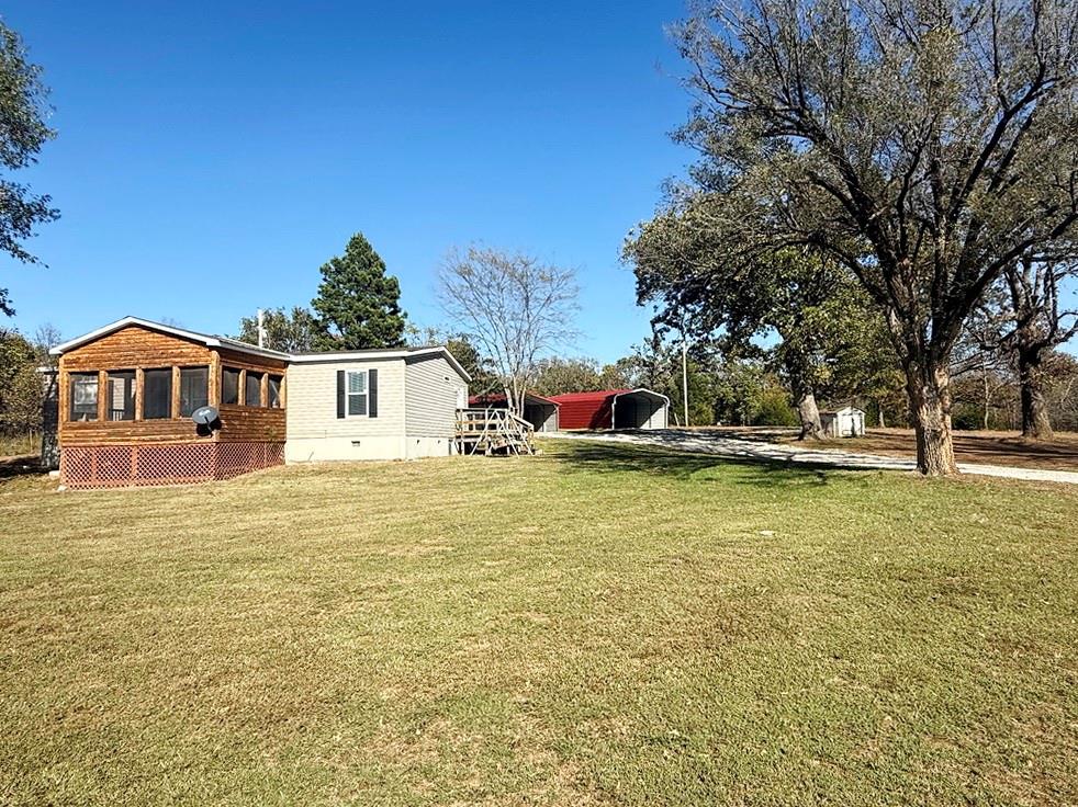 Country Living Near Three Lakes!
Enjoy quiet, rural life living in this well-kept 3-bedroom, 2-bath manufactured home built in 2019, offering 1,174 sq. ft. of comfortable living space on 1.4 acres. The property is surrounded by mature oak trees and a pine tree, providing plenty of shade and a serene country feel on blacktop frontage. Step inside to an inviting interior featuring a spacious master bedroom with a large double closet, and a newer oven/range in the kitchen. A 12x15 screened-in porch offers the perfect spot to relax and enjoy the outdoors.Outside, you’ll find two covered parking areas—an 18x20 and an 18x25 carport—providing space for multiple vehicles, boats, or recreational toys. The property also includes a charming vintage cellar, newer septic system, and a clean, reseeded lot where an old home and trailer were recently removed. A sturdy 8½ x 40 concrete pad offers endless possibilities—RV parking, patio area, or future building site.Located less than 10 minutes from Truman Lake and only about 30 minutes from both Pomme de Terre Lake and Stockton Lake, this home sits in the heart of one of Missouri’s best recreation areas in the northern Ozarks. Fiber internet is available, property taxes are just $490, and the low cost of living makes this a smart and affordable move.Whether you’re looking for a full-time residence, a weekend getaway, or a lake-area investment, this property is ready to welcome you home!