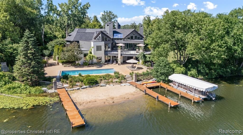 Presenting a once in a lifetime opportunity to own a private island in one of Michigan’s most exclusive all sports lake communities. With a local reputation of prestige and mystique, Lake Sherwood is the pinnacle of lakefront communities in affluent Oakland County and is surrounded by the most bustling upscale metropolis’ in the country, just minutes from downtown Milford. 4912 Oakwood Court is a nearly 1.6-acre legacy parcel tucked at the way back of a conveniently situated cul-de-sac that enjoys 1,500+ feet of prime waterfront and, without its long and elegant tree lined driveway, would be entirely surrounded by pristine waters. This rare island is improved by an architectural masterpiece, a timeless estate home designed to be acquired by a buyer that understands its place as the pride of a truly private, residents only lake. This home features a plethora of natural sunlight, rustic stone fireplaces complete with imported limestone mantles, WOLF appliances, and lustrous white maple hardwood flooring, together crafting one of the finest residences in the state. The fluid layout, and extremely thoughtful features offer the highest degree of functionality for any lifestyle; ultimate control and privacy is one of the many benefits this property offers. The spacious terrace overlooking the resort style pool complete with a breathtaking lake view sits just steps away from the Northern Michigan grown cedar docks that your grandchildren will walk on, which offer permanent docking solutions for your boats. Situated in the “no wake” part of the lake, this ONE of ONE property is mere seconds from the vast oasis that is Lake Sherwood. Every part of the property offers jaw dropping lake views, including the towering outdoor fireplace just off the pool. Complete with spacious and well-manicured rolling grounds fit for a tennis court, an additional structure, or whatever else you decide to feature, this incredible estate is an asset to enjoy and design a lifestyle around.