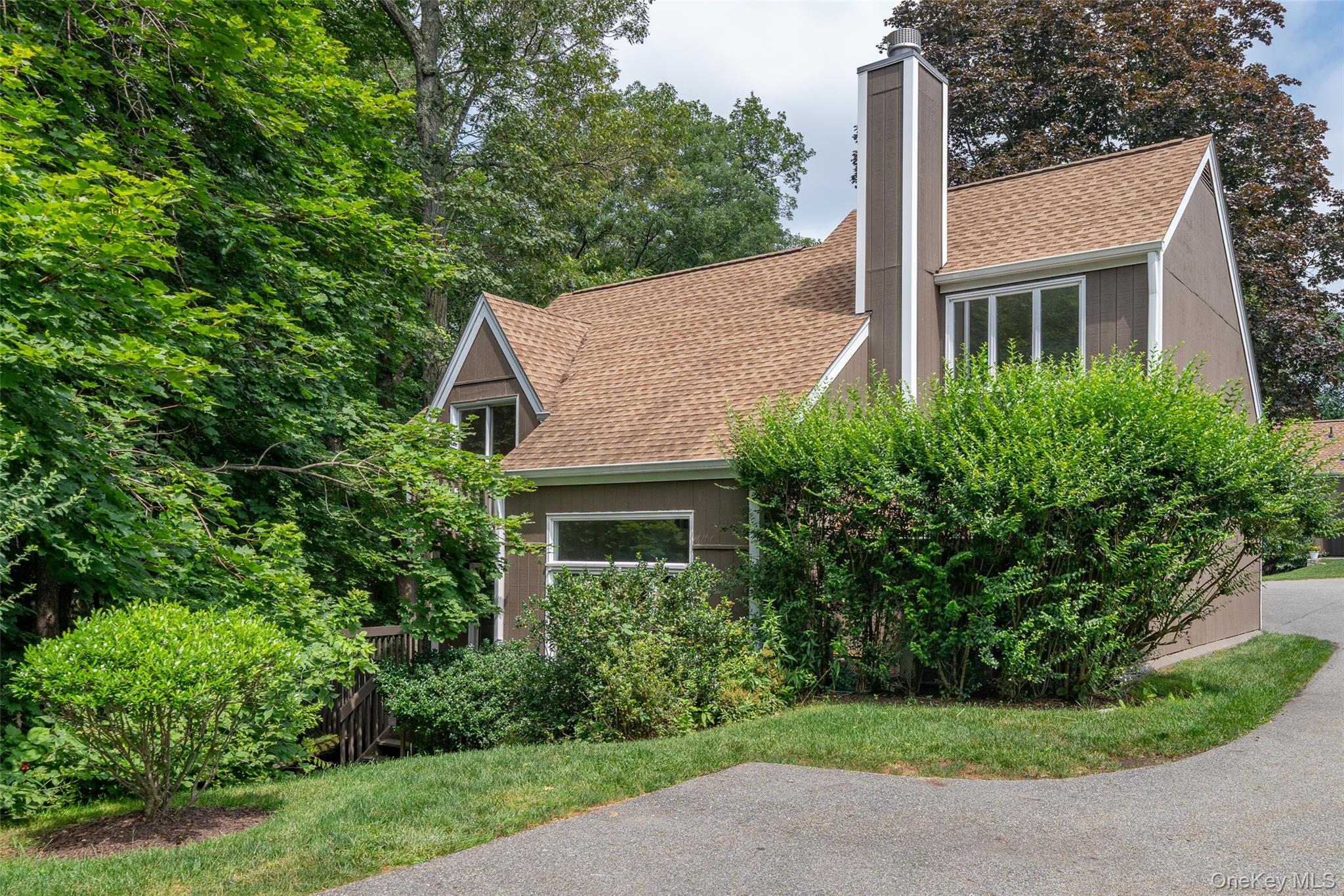 All the space and privacy of a single-family home with the ease of condo living! One of the few completely stand-alone and private townhouses in Apple Hill Farm, this spacious 2-bedroom, 2.5-bath home offers a rare blend of comfort, style, and convenience. Enjoy the serene setting from a large wrap-around wood deck overlooking lush, wooded views—perfect for morning coffee or evening entertaining. Inside, the sunny living room features a cozy wood-burning fireplace, oversized windows, and flows seamlessly into the formal dining area with sliding glass doors to the deck. The updated kitchen boasts custom cabinetry, brand-new stainless steel appliances, and its own access to the deck ideal for grilling or gatherings. All bathrooms have been newly and tastefully renovated with quartz vanities and striking tile flooring, bringing a luxurious feel throughout. Additional highlights include wood floors throughout, many new windows, a new roof and skylights (2019), and a new driveway and cul-de-sac (2019). Storage is plentiful with large closets, a pull-down attic, crawl space, and an attached garage. Apple Hill Farm is a private, tranquil community offering a pool and tennis courts, all just minutes from town, train, and top-rated Chappaqua schools. This move-in-ready home offers it all—privacy, space, and low-maintenance living in a coveted location.