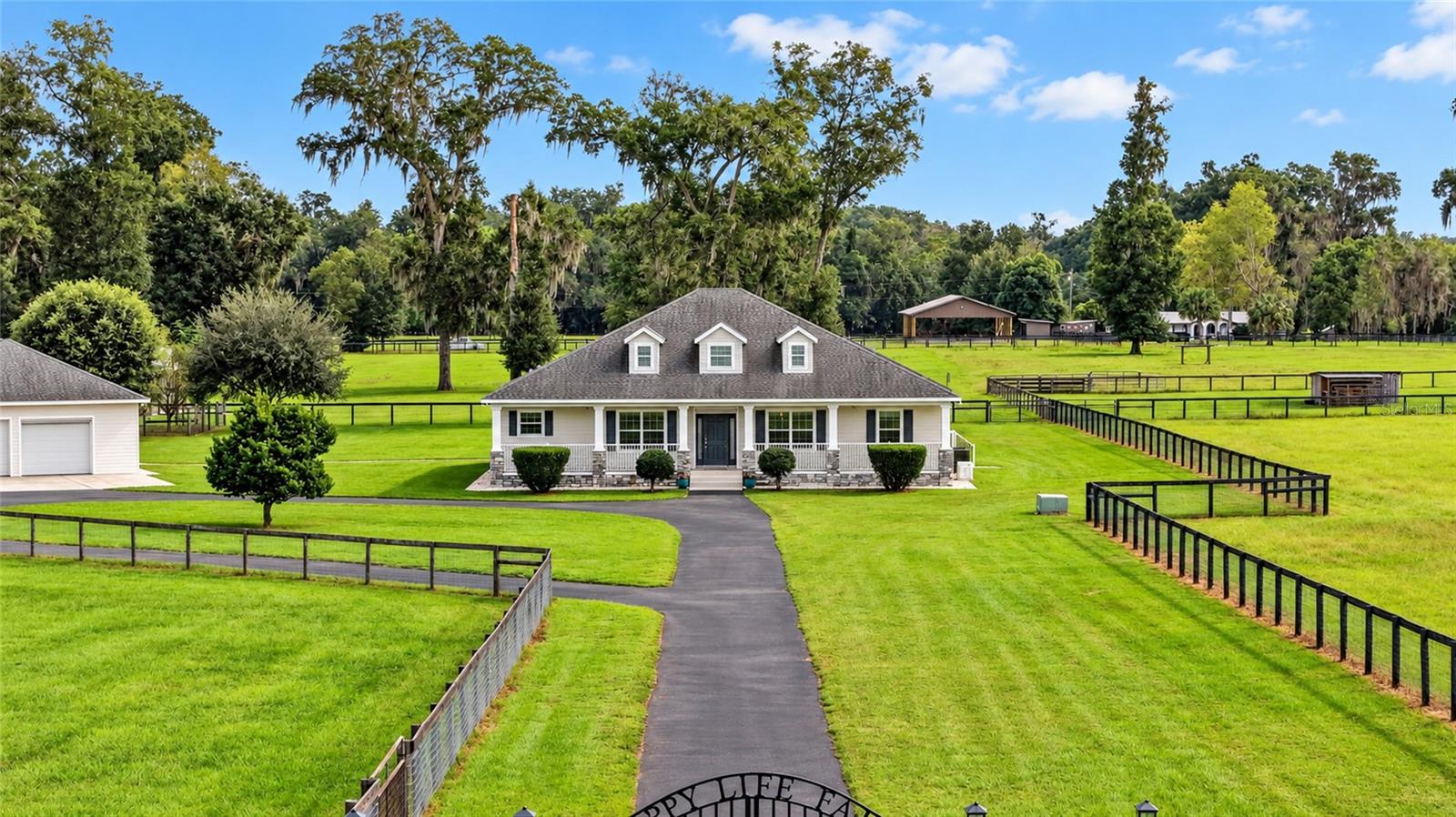 This versatile, 13.58 acre farm is located on a private, paved road and offers peaceful country living within easy reach of Ocala and Gainesville’s shopping, dining, healthcare, and cultural attractions. Built in 2018 with insulated concrete block construction, the custom 3-bedroom, 2-bath home with spacious office/den features an inviting open floor plan and luxury vinyl plank flooring throughout. The large kitchen offers granite countertops, abundant cabinetry, and plenty of workspace for preparing meals or gathering with friends. Start your morning with sunrise views from the screened lanai overlooking the heated saltwater pool and spa, then settle onto the welcoming front porch for sunset. This gated property is perimeter fenced and cross-fenced into four pastures with water lines to each and includes a pole barn and loafing shed. The farm has been managed using regenerative and organic practices. The land's mature pasture and minimal slope is well suited to horses and other agricultural pursuits. Fruit trees and dedicated areas for chickens and gardening add to the possibilities for sustainable living. The detached 1,200-square-foot, three-car garage with 8' tall roll-up doors offers generous space for vehicles, storage, and a workshop. Underground utilities, fiber optic internet, and a 22-kW whole-house generator bring everyday convenience and added peace of mind to farm life. The home and detached garage have recently received new exterior paint providing a fresh, welcoming appearance. In 2022 Tesla solar panels and Powerwall battery storage were added and are owned outright, keeping utility bills minimal for a property of this size—an appealing finishing touch to a farm designed for comfortable, productive country living.
