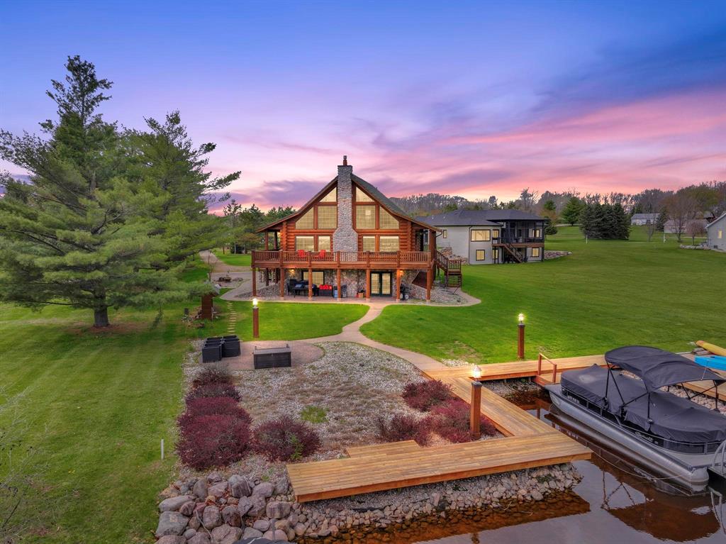 Welcome to a rare offering on the canal of Lake Isabella--where timeless craftsmanship meets expansive waterfront living. This stunning 4,000+ square foot log home delivers the perfect blend of rustic elegance and modern comfort, with direct canal access leading you out to all-sports Lake Isabella. Step inside and be captivated by the soaring ceilings and a floor to ceiling stone gas fireplace that anchors the grand living space, creating a warm and unforgettable focal point. Natural wood finishes, abundant light, and an open concept design make the home ideal for both everyday living and entertaining on a grand scale. The spacious layout features 4 bedrooms and 4 bathrooms, offering flexibility for guests, multi-generational living, or hosting weekend getaways. The fully finished lower walk-out level expands your living space with room for recreation, relaxation, or a private retreat--perfectly suited for lake life. Outdoors, enjoy peaceful canal front views with your own dock, ideal for boating, kayaking, and swimming. Whether you're enjoying quiet mornings on the water or lively summer evenings with friends and family, this property captures the essence of Northern Michigan living.
