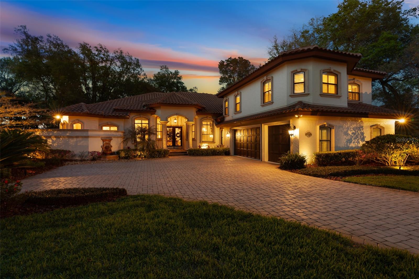 Discover an unparalleled level of luxury at 7341 Bella Foresta Place, an extraordinary custom estate on a premier one-acre homesite within the private, gated enclave of Bella Foresta. This residence combines exceptional craftsmanship, robust mechanical systems, and resort-style living to create a sanctuary of sophistication and privacy.The journey begins at the grand entrance, where massive cast stone columns frame custom mahogany-toned double doors with intricate wrought-iron scrollwork. Guests enter a grand foyer showcasing a dramatic ceiling and timeless travertine flooring throughout the main living areas. The formal living room serves as a refined greeting space with a custom coffered ceiling, natural gas fireplace with a decorative tile mantle, and bay windows with private access to the lanai oasis. An executive home office features glass French doors and a double-tray ceiling, while the formal dining room is elegantly appointed with recessed accent lighting. The expansive family room showcases 10-foot pocket sliding glass doors that disappear to create a seamless transition to the pool courtyard.The chef's kitchen is designed for grand-scale entertaining, boasting 42" custom two-tone dovetail cabinetry, a mosaic tile backsplash, and granite countertops. A central prep island and massive wraparound bar complement the natural gas cooktop with custom range hood, pot filler, and stainless-steel appliances while the light-filled breakfast nook features panoramic bay windows overlooking the manicured grounds. The owner's retreat offers a serene sanctuary with private lanai access and a spa-inspired bath featuring travertine floors, split granite vanities, and a massive tile walk-in shower with vertical mosaic accents. Dual "his and hers" walk-in closets feature full custom built-in organization systems.The thoughtful layout includes a private downstairs guest wing addition (2012) featuring a guest suite with double-door entry and a high-end en-suite bath. The upper level provides exceptional flexibility with a massive bonus room--ideal for a theater or game room--alongside an additional guest bedroom with a private en-suite bath. A dedicated home gym with tray ceilings and direct pool access ensures a seamless fitness lifestyle.Step outside to a spectacular resort-style outdoor living space. The expansive paver lanai offers multiple covered seating areas and a gas-heated chlorine pool and spa (equipment updated 2022) featuring a modern sculptural waterfall ledge and outdoor shower. Beyond the courtyard, the sprawling one-acre estate offers exceptional privacy and manicured lawn space maintained by a city reclaimed irrigation system.The oversized 3-car garage features 8-foot insulated doors and freshly painted floors, providing ample space for vehicles and storage. Upgrades include:-Whole-house Generac generator with automatic transfer switch-Two gas tankless water heaters (installed 2021)-Four-zone HVAC system for precision climate control-2015 Tile Roof for lasting durability and curb appeal-Natural gas fireplace with custom tile mantle-Built-in mudroom bench and transition hallway storage-Full appliance package included-City reclaimed water irrigation system7341 Bella Foresta Place is a rare opportunity to own a premier custom luxury estate where craftsmanship, technology, and resort-style living converge.