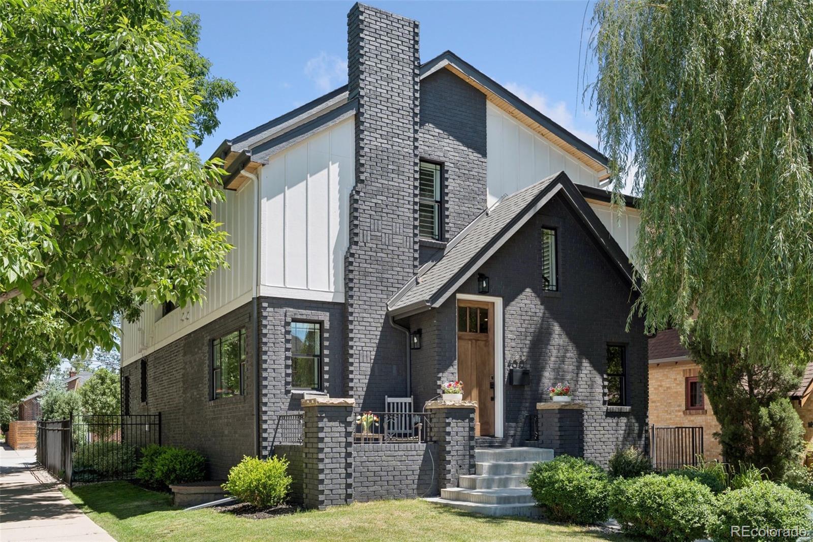 Set on a corner lot in East Washington Park, this classic brick residence was built in 1932 and rebuilt from the foundation up in 2019. Charcoal brick, white board-and-batten siding, prairie-style windows, and a prominent chimney give the home architectural character, while a weeping willow provides ample afternoon shade. Inside, the home features hardwood floors, high ceilings, interior shutters and Lutron automatic shades, and a fully integrated Elan smart home system. The main level offers an open layout with a living room anchored by a stacked stone gas fireplace that flows into the dining room and kitchen. The kitchen serves as the center of the home, appointed with high-end appliances including a Thermador range, quartz countertops, and a large central island. A main level office with French doors provides an ideal place to work from home, and a powder room with timeless finishes and a mudroom with built-in bench seating complete the first level. Upstairs, the primary suite is framed by arched windows on both sides of the bed, flooding the room with natural light. The spa-like five-piece en suite bathroom features a soaking tub, a glass-enclosed shower, and a double vanity, and the adjoining walk-in closet includes custom built-ins and a second washer/dryer. Two additional bedrooms (including one with a custom built-in wall bed) and a full bathroom complete the upper level. The finished basement provides a second living area with a wet bar and integrated media setup (perfect for movie night). A fourth bedroom (currently used as a home gym), a 3/4 bathroom, and a laundry closet round out the lower level. The professionally landscaped back yard creates an exceptional outdoor living space, featuring a bluestone patio with an outdoor kitchen and fire pit, a lawn area, and a detached two-car garage. Perfectly located between Cherry Creek and Wash Park with easy access to Old South Gaylord Street, downtown Denver, and I-25. Buyer to verify all information.