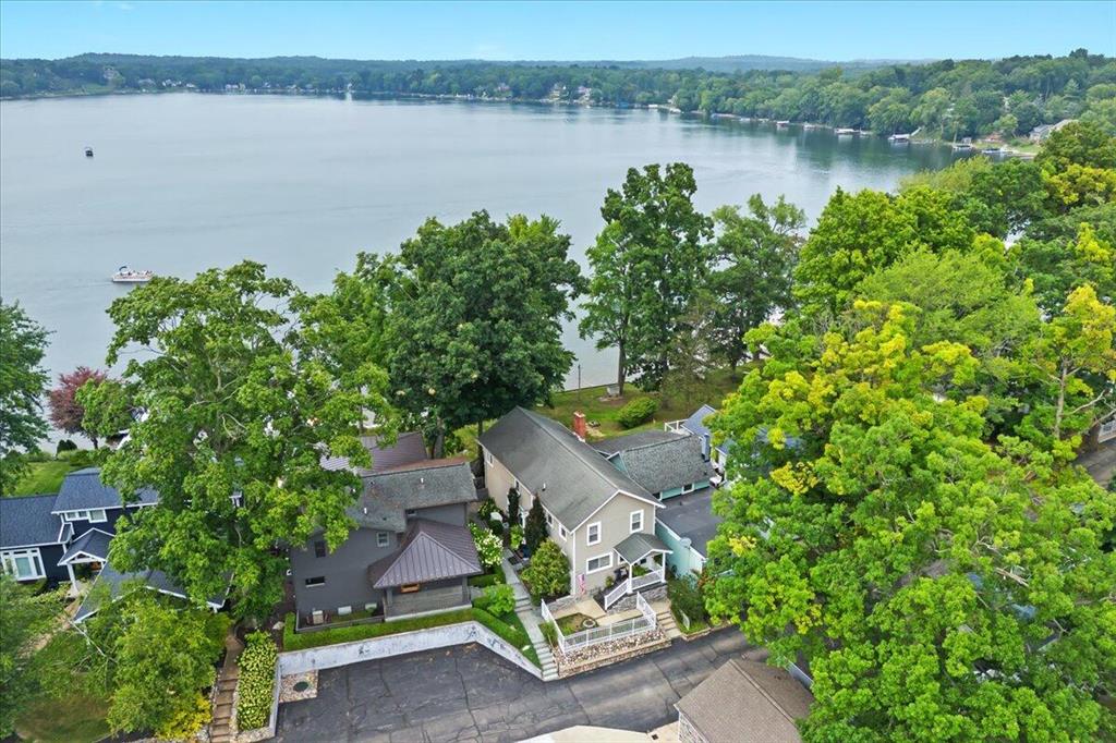 Welcome to this beautifully maintained and thoughtfully updated home, perfectly positioned to capture breathtaking views of Cavanaugh Lake. The spacious living room features a dramatic wall of windows framing the water, while a cozy gas fireplace with sleek black slate surround and built-ins adds modern flair. The dining room is ideal for entertaining, complete with a built-in credenza for extra storage and serving space. Newer wood flooring, fresh paint, crown molding, and stylish wallpaper give the home a fresh, designer feel. The efficient kitchen offers a tiled backsplash, stainless steel appliances, and a built-in snack bar--perfect for quick meals on the go. An updated powder room completes the main level. Upstairs, follow the slate stairway to the primary bedroom retreat,where you'll wake each morning to gorgeous lake views. A walk-in closet, plus a vanity and sink, provide comfort and convenience. The second floor also features an updated full bath and two additional bedrooms. The unfinished basement offers abundant storage, laundry, and an additional full bath. Outdoors, enjoy endless summer days on the lake, or relax on the spacious deck, ideal for outdoor dining, entertaining, or unwinding with your favorite book. A gazebo adds extra privacy and shade, and the whole house generator adds comfort knowing you won't be without power.  Whether you're looking for a year round home, or a summer get away, don't miss your chance to experience all that Cavanaugh Lake living has to offer. Conveniently located near downtown Chelsea, with an easy commute to Ann Arbor, Jackson, Metro airport and more. Chelsea Schools!
