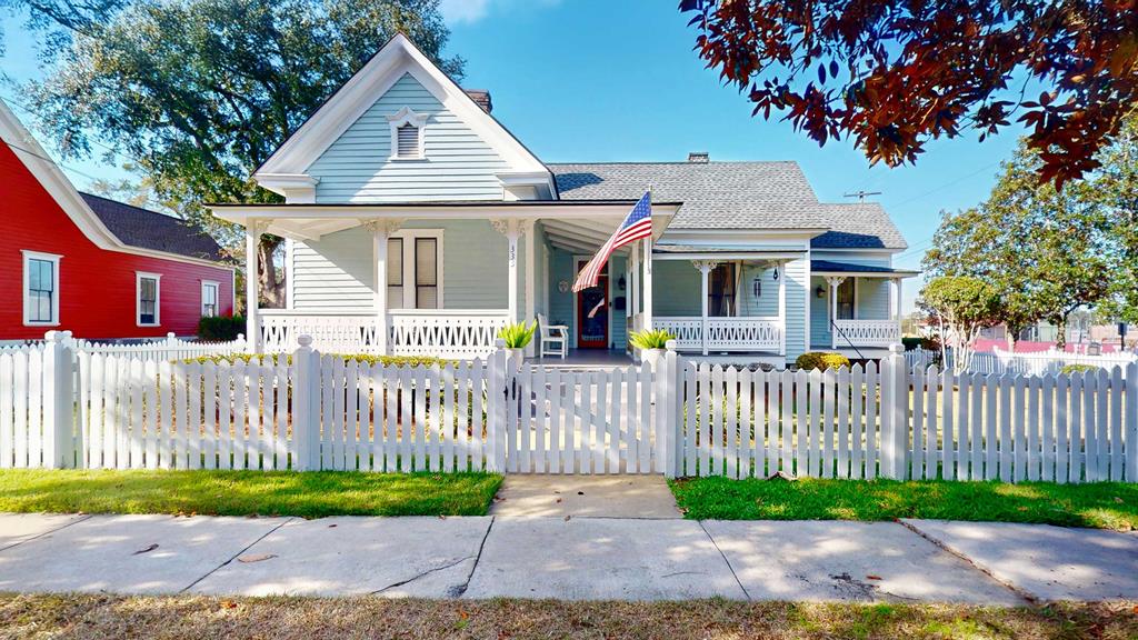 The Maggie Love Hall House is an unforgettable and rare treasure in Thomasville's beloved Warren & Love Historic Tocwotten District. If you've been looking for that home with the perfect white picket fence, THIS IS IT! Wave to your neighbors as they ride by on golf carts or relax on the swing on the large porch. Experience a charming home like never before with 2 bedrooms, 2 bathrooms, gorgeous heart pine wood floors, two decorative fireplaces, built-in bookcases, and high ceilings. Enjoy nights in at home in the cozy living room and make the most of the surround sound system. Entertain guests in style in the formal dining room or cook unforgettable meals in the kitchen with stainless steel double ovens, microwave, and cooktop. The primary suite offers luxury and comfort with a decorative fireplace and a primary bathroom complete with a walk-in shower and walk-in closet. Step outside into the  backyard where you'll find a detached two bay garage with attached covered porch, and a fenced in area with a fire pit that's perfect for roasting marshmallows with guests and a  swim spa.  Porches, porches, and more porches; there's two separate porches in front and and a large screened-in porch in back. And... the lifestyle is unbeatable! Walk to Grassroots Coffee, Jonah's Fish and Grits, the amphitheatre,, First Friday Sip & Stroll, the Rose Festival, and Victorian Christmas. The Big Oak, boutique shops, local restaurants, and schools are all just minutes away— making errands and nights out effortless! These sellers have thought of everything.  The house is meticulous, updated, and has plenty of room for enjoyment and entertaining. Best of all, the sidewalk in front of this home leads all the way downtown!