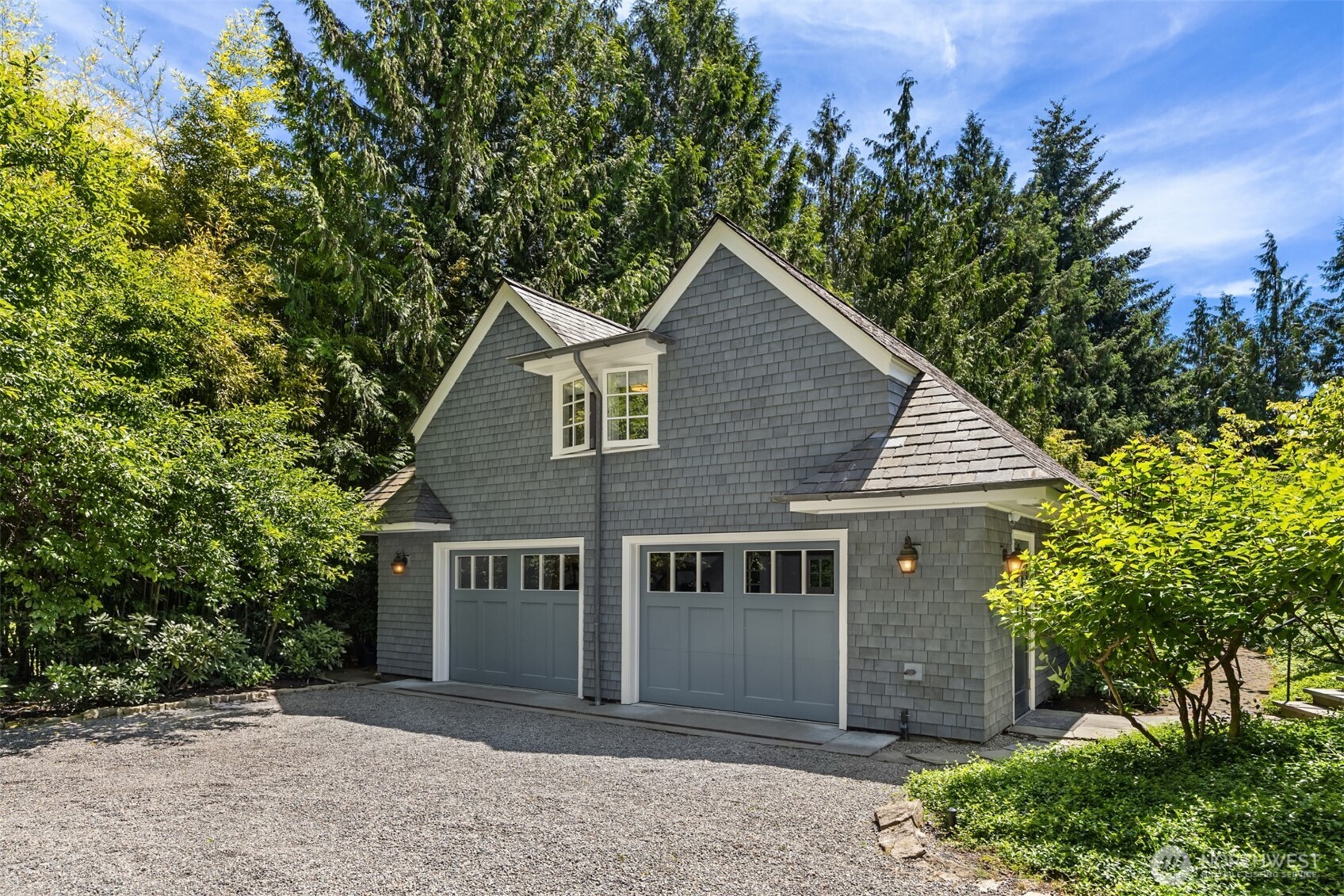 Charming shingle-style detached garage surrounded by mature trees.