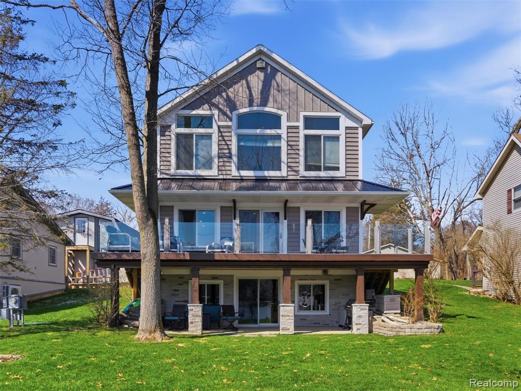 Life on Lobdell Lake delivers that sought-after “up north” feeling—without the long drive. With 57 feet of beautiful waterfront frontage this exceptional property offers a rare blend of relaxation, recreation, and everyday comfort. Built in 2004, the home features 2800 sq ft of custom designed living space which includes a finished walkout basement. The exterior has been tastefully updated with board and batten and Carolina coastal beaded siding, stone accents, and new entry doors creating standout curb appeal. The Azek board deck with a glass panel surround provides the perfect setting to take in the water and unwind. Inside, large windows fill the home with natural light and showcase the incredible lake views. The open-concept layout connects the kitchen, dining, and living areas, making it ideal for both entertaining and everyday living. The kitchen is well-appointed with granite countertops, a center island, stainless steel appliances (new in 2024). The primary en suite offers a comfortable retreat with a spacious walk-in closet, dual vanities, and a large tiled walk-in shower. Additional bedrooms are generously sized, and the finished walkout basement adds valuable living space with barn wood accent walls, refreshed bathroom and direct access to a covered patio. Outdoor living is just as impressive, with a built-in fire pit, entertaining space, and peaceful surroundings filled with wildlife. Across the street, an additional lot includes a pole barn and is located on Little Darling Lake. The garage includes 100-amp electrical service and three EV chargers—two in the garage and one in the pole barn. Residents of Lobdell Lake enjoy an active and vibrant lifestyle, with events and opportunities supported by the local lake association, along with boating, fishing, and year-round enjoyment right outside your door. Beautifully maintained and full of character, this waterfront home captures the essence of lake living—peaceful, scenic, and effortlessly enjoyable.