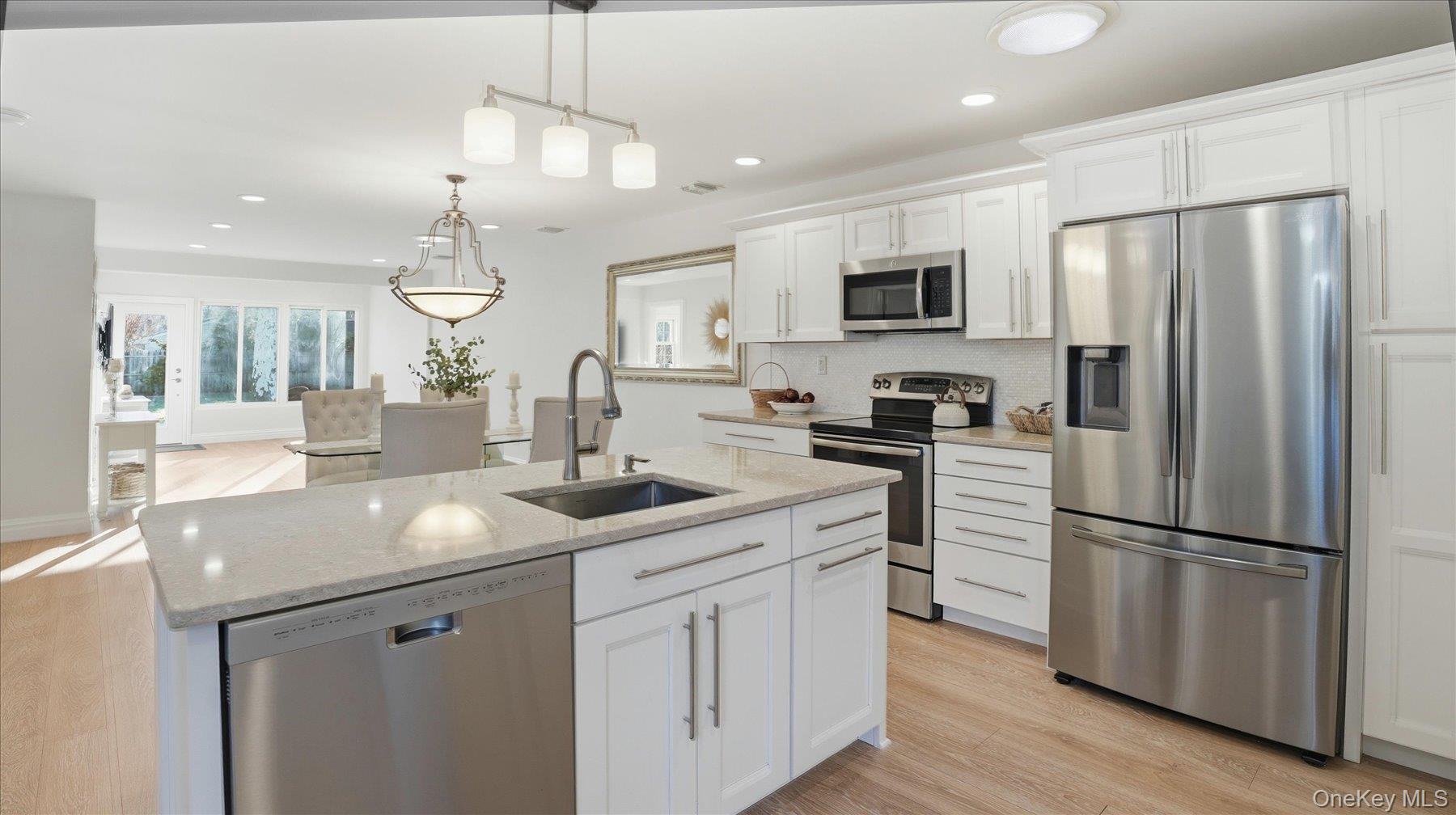 Welcome home to this gorgeous 2-bedroom, 2-bath condo nestled in the charming          55+ community of “The Knolls at Stony Brook.” This stunning condo has had a complete renovation. Interior walls were removed to create a true open floor plan for modern living.  It features a beautiful chef’s granite kitchen with a center island, and stainless-steel appliances that opens to a spacious dining and living room, ideal for enjoyable family gatherings. Additional upgrades include all new doors and moldings, laminate flooring throughout and recessed lighting.                The primary bedroom redesign includes a large “walk in” closet and expanded shower in the primary bath. All freshly painted and overlooking a wall of glass on to the serene backyard which includes a paver patio for outdoor entertaining.  The second bedroom, beautiful hall bath, along with a pristine one car garage with direct access to the kitchen, epoxy flooring and storage space, completes this one-of-a-kind gem.The community offers fantastic amenities, including a clubhouse with social calendar, outdoor pool, lawn maintenance, and snow removal. An added bonus is the prime location of this condo nearby to the clubhouse and pool. You will have the ability to take a short stroll to all the fun and leave your car at home. Low taxes and monthly maintenance fees.