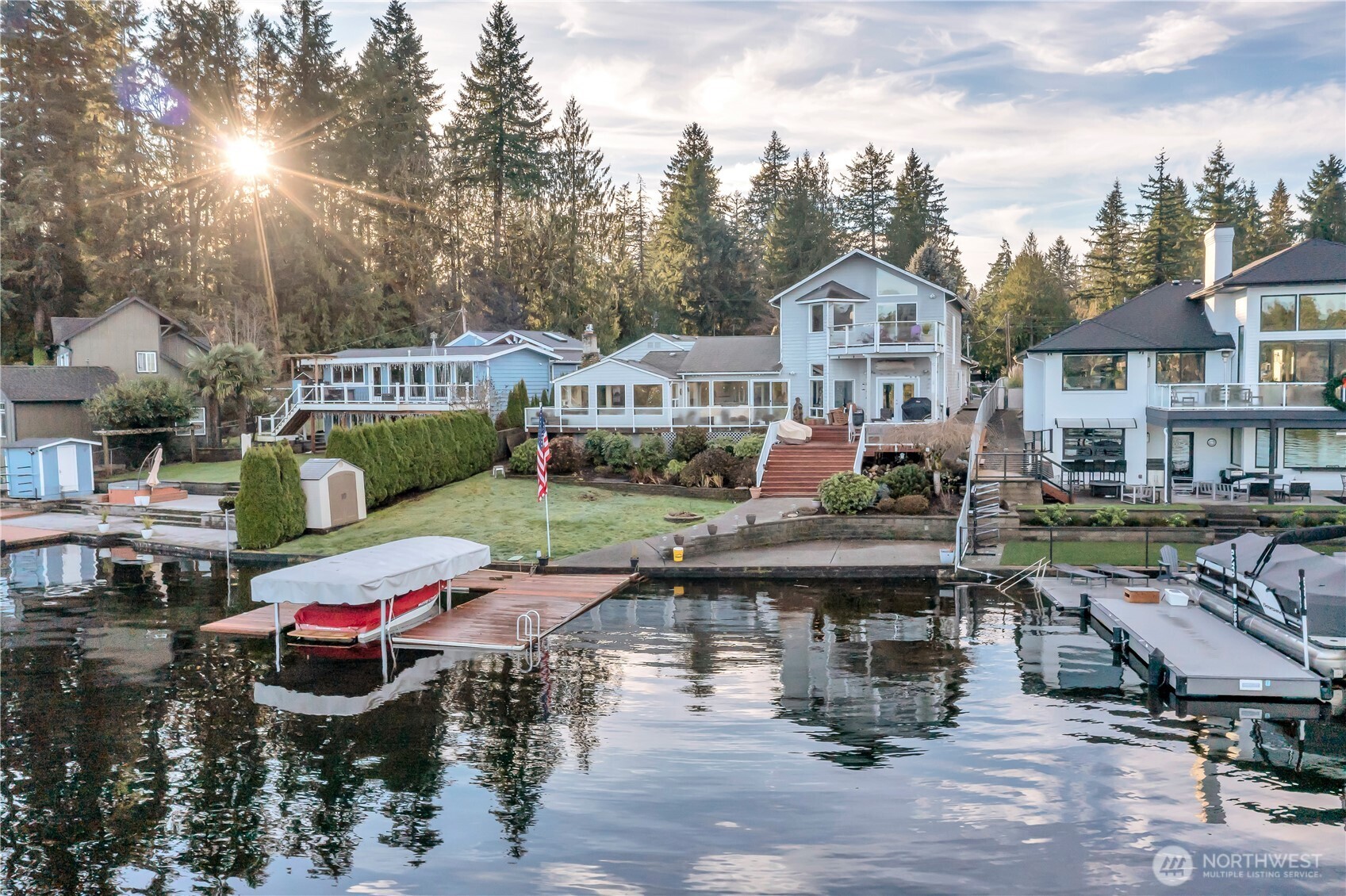 A rare chance to claim a breathtaking no-bank Lake Sawyer estate with 80 ft of pristine shoreline, private dock and boat lift.  This custom retreat delivers resort-style living with soaring ceilings, dramatic lake-facing windows and rich hardwoods.  Main level offers 2 bedrooms, full and 3/4 baths, gas rock fireplace, freestanding stove, dual-fuel range and a stunning sunroom over the water.  The lavish primary suite stuns with a lake-view jacuzzi, private balcony, coffee bar, exercise room and walk-in closet.  Outdoors impress with a covered lakeside patio, firepit, whole-house generator, lake-water irrigation, theater outbuilding, storage, 2-car garage and manicured grounds.