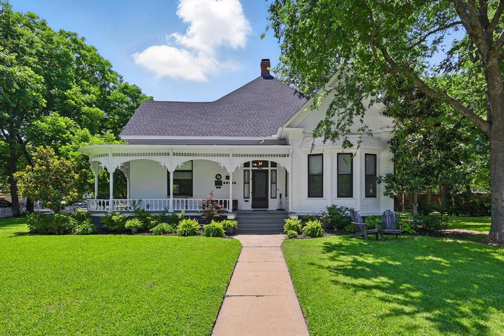 Step into a piece of Fort Worth history with the MA Benton House, a beautifully restored Victorian-era home located on a 4-lot corner in the heart of Fairmount. Built in 1898, this residence stands as one of the oldest homes in Fort Worth & is listed on the National Register of Historic Places as well as recognized as a Texas Historic Landmark. The home has been lovingly remodeled with close attention to detail. The wraparound porch with detailed molding, framed by a white picket fence & lush green lawn, evokes nostalgic summer days spent sipping lemonade. Inside, original hardwoods, soaring ceilings, transom windows & intricate architectural details reflect the home’s historic charm. Just off the entry, the living room is filled with natural light & is grounded by a wood burning fireplace. On the opposite side, a stately study features floor-to-ceiling bookshelves, complete with a rolling ladder & fireplace. Original light fixtures glow with timeless charm, while the updated kitchen offers the best of both worlds—ss appliances, Carrara marble counters & a butcher block island that complements the historic aesthetic. Adding to the modern luxuries, the family room off the kitchen makes the perfect spot for relaxing, while a nearby mudroom serves as central hub for study, storage or organizing daily life. The first-floor primary suite offers privacy & comfort with an ensuite bathroom, double sinks, separate soaking tub, shower & large walk-in closet. Upstairs, is a game room, climbing wall, 2 additional bedrooms with quaint reading nooks & a full bath. For guests or extended family, a guest house has its own bedroom, living area, kitchen & bath. A detached 2-car garage sits conveniently on the corner, while the expansive yard offers endless possibilities: a tree swing, space for croquet matches or even a chicken coop or workshop. Perfectly located in Central Fort Worth, this property is more than a residence—it’s a storybook home filled with history, heart & heritage.