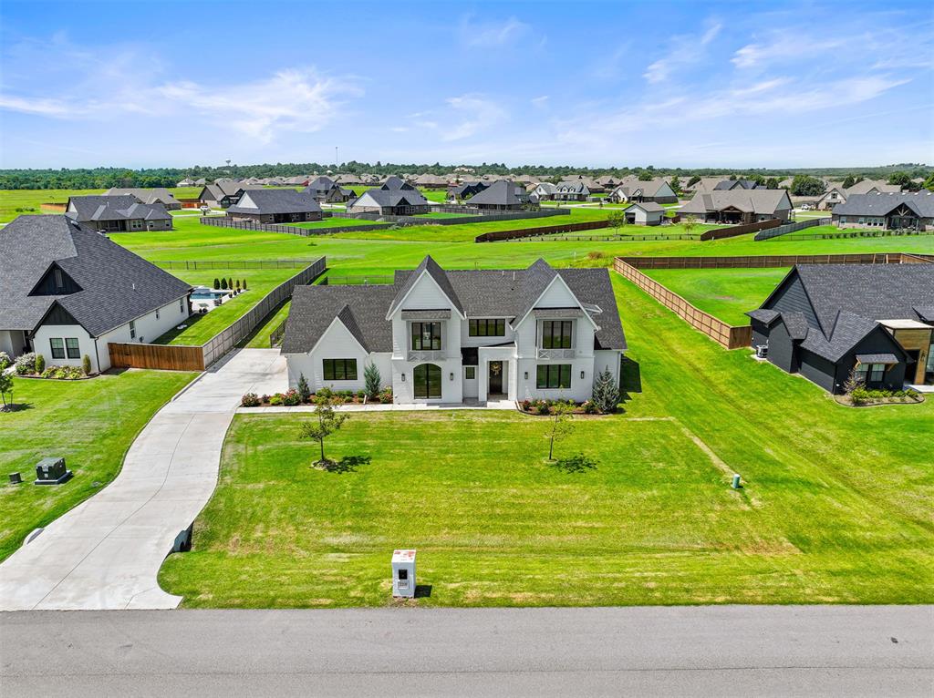 Welcome to this exceptional modern residence in the highly sought after Brentwood Addition in Norman, just minutes from Hwy 9. Set on a generous 0.75 acre lot, this home makes a striking first impression with its eye-catching front elevation, wrought iron fencing, and a covered back patio ideal for enjoying beautiful Oklahoma sunsets.From the moment you step inside, you’re greeted with expansive sightlines that draw you through the home and out to the serene backyard. The open concept design is perfectly suited for both everyday living and elegant entertaining, anchored by a show stopping kitchen featuring a massive center island, abundant custom cabinetry, gas appliances, and an oversized walk in pantry. The adjoining dining area offers peaceful backyard views, creating a seamless flow for gatherings both large and small.The living room is equally impressive with soaring 12 foot ceilings, a dramatic floor to ceiling fireplace, and walls of natural light that fill the space with warmth and sophistication. The main level includes four bedrooms (or three plus a dedicated office), 2.5 bathrooms, a functional mud bench, and a beautifully designed laundry room. The luxurious primary suite is a true retreat, complete with dual vanities, a spacious walk-in shower, freestanding soaking tub, and an exceptional closet.Upstairs, you’ll find a versatile bonus room, an additional bedroom, and a full bathroom, perfect for guests, teens, or a private living space. As the first resale in the neighborhood and only two years old, this home offers the feel of new construction without the wait. Thoughtfully designed and meticulously maintained, this is a rare opportunity in one of Norman’s most desirable communities. Don't miss your chance to call this one home. *USDA ELIGIBLE*