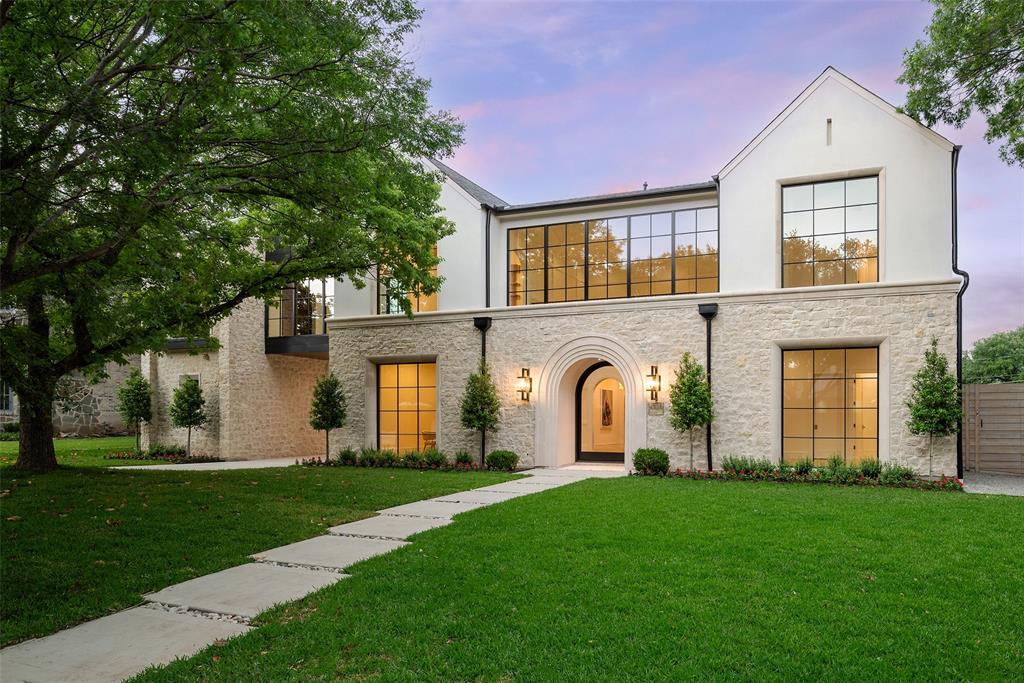 Situated in Preston Hollow, 6823 Norway Rd. is a custom luxury home by M&E Development, reflecting refined craftsmanship and enduring design. Blending timeless architecture with thoughtful modern living, this residence showcases balanced proportions and elevated finishes throughout. A striking limestone façade with graceful arches creates an elegant street presence. Inside, a dramatic two-story foyer with marble floors and an elegant staircase welcomes you into light-filled interiors designed for both everyday comfort and upscale entertaining. The main living area features vaulted, beam-accented ceilings and a statement fireplace, flowing effortlessly into the chef’s kitchen equipped with premium appliances, custom cabinetry, a scullery and a well-appointed butler’s pantry. The first-floor primary suite offers a private retreat with serene backyard views, a spa-inspired marble bath, and an expansive custom walk-in closet. A flexible downstairs room with a full bath provides versatility for a guest suite, office, or home gym. Upstairs, three en-suite bedrooms are complemented by a study nook and a generous game room, offering functional living for all stages of life. Outdoor living is enhanced by a covered loggia and summer kitchen, ideal for entertaining or quiet evenings at home. Additional highlights include a gated motor court, porte-cochère, and two garages, delivering both privacy and convenience.